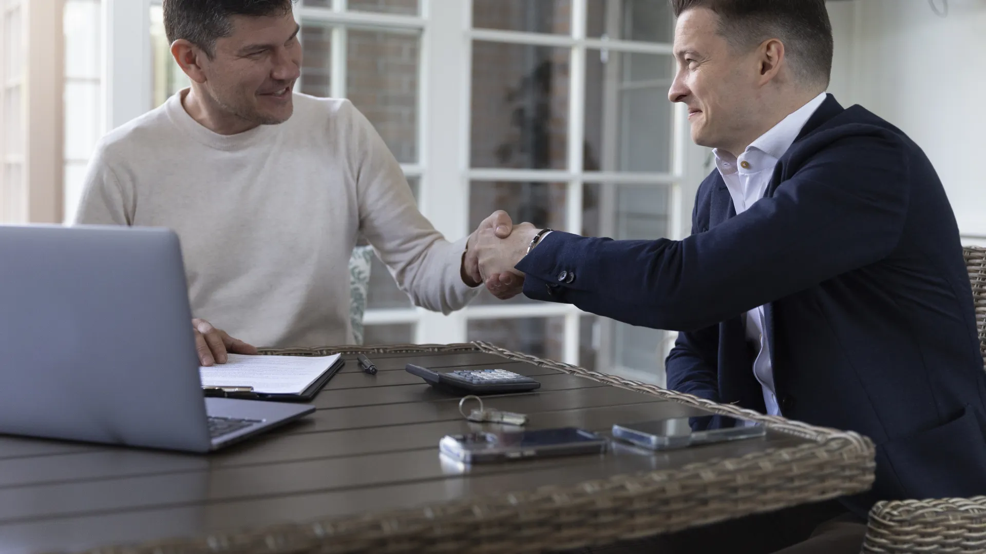 two men shaking hands over a service agreement