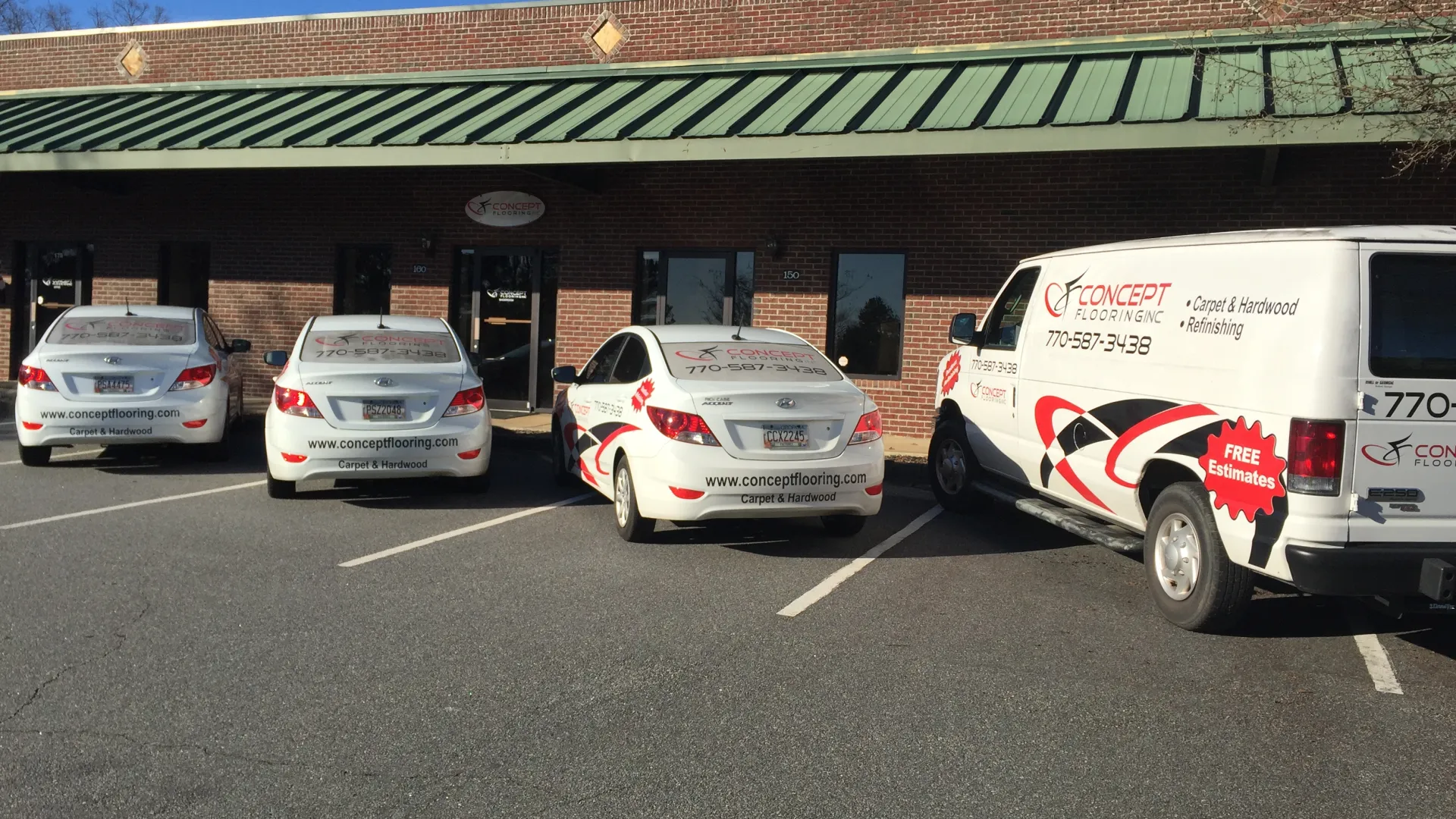 Fleet of Concept Flooring company vehicles parked in front of their office with branding and contact information visible.