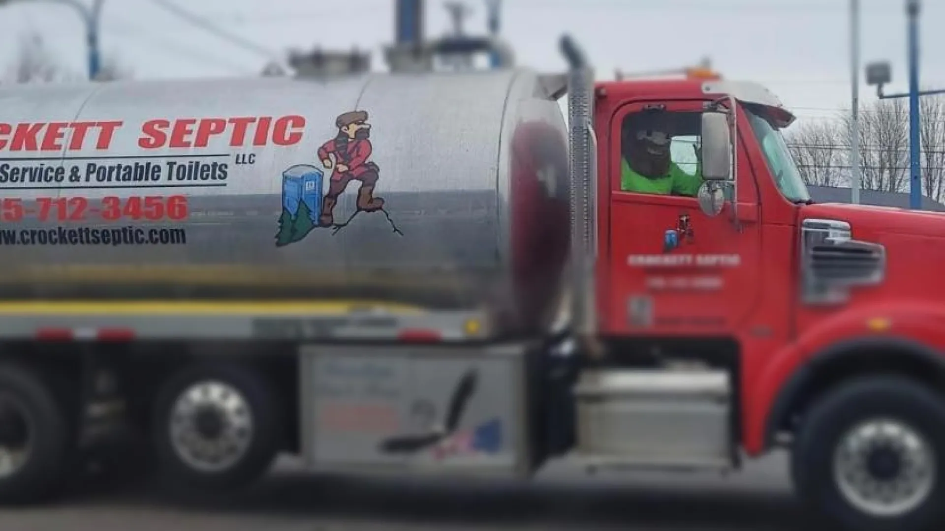 Crockett Septic truck parked with service information and graphic on the side.