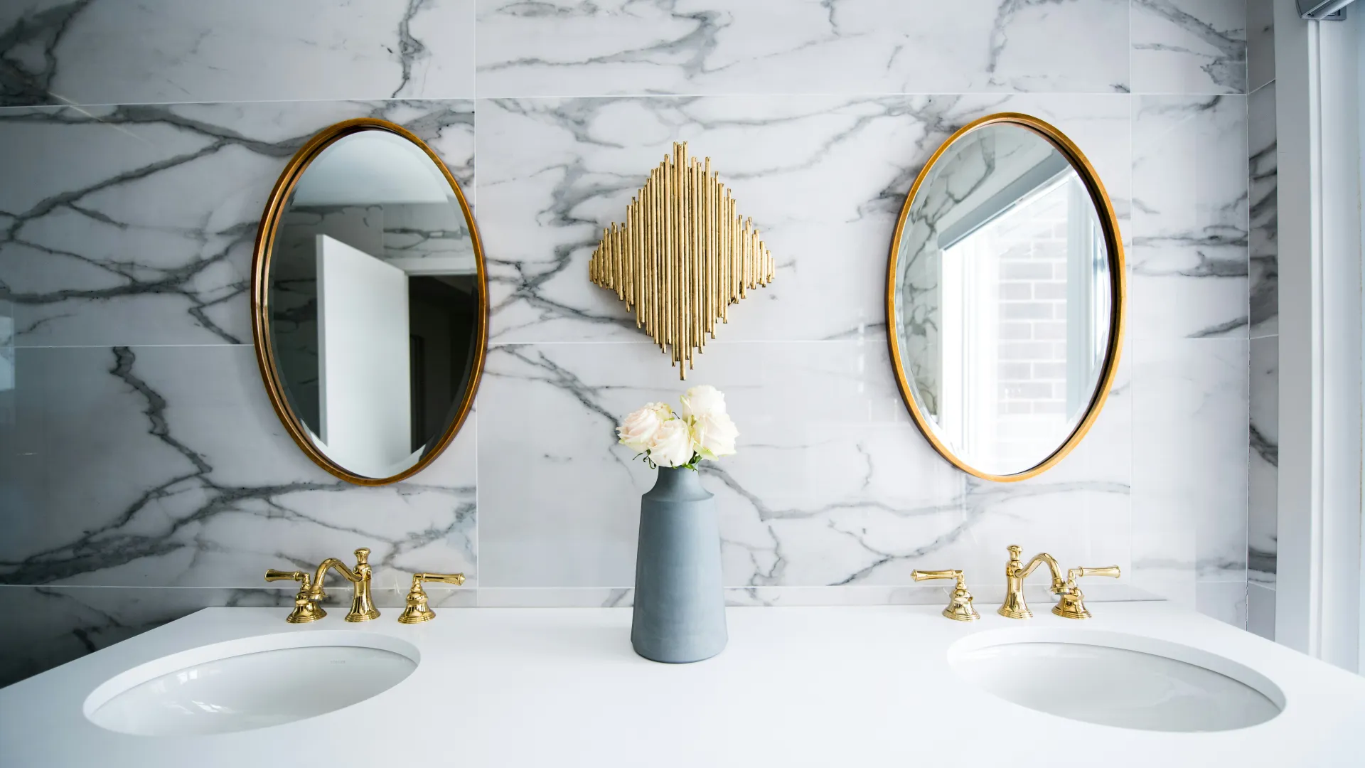 a counter with sinks and a vase of flowers