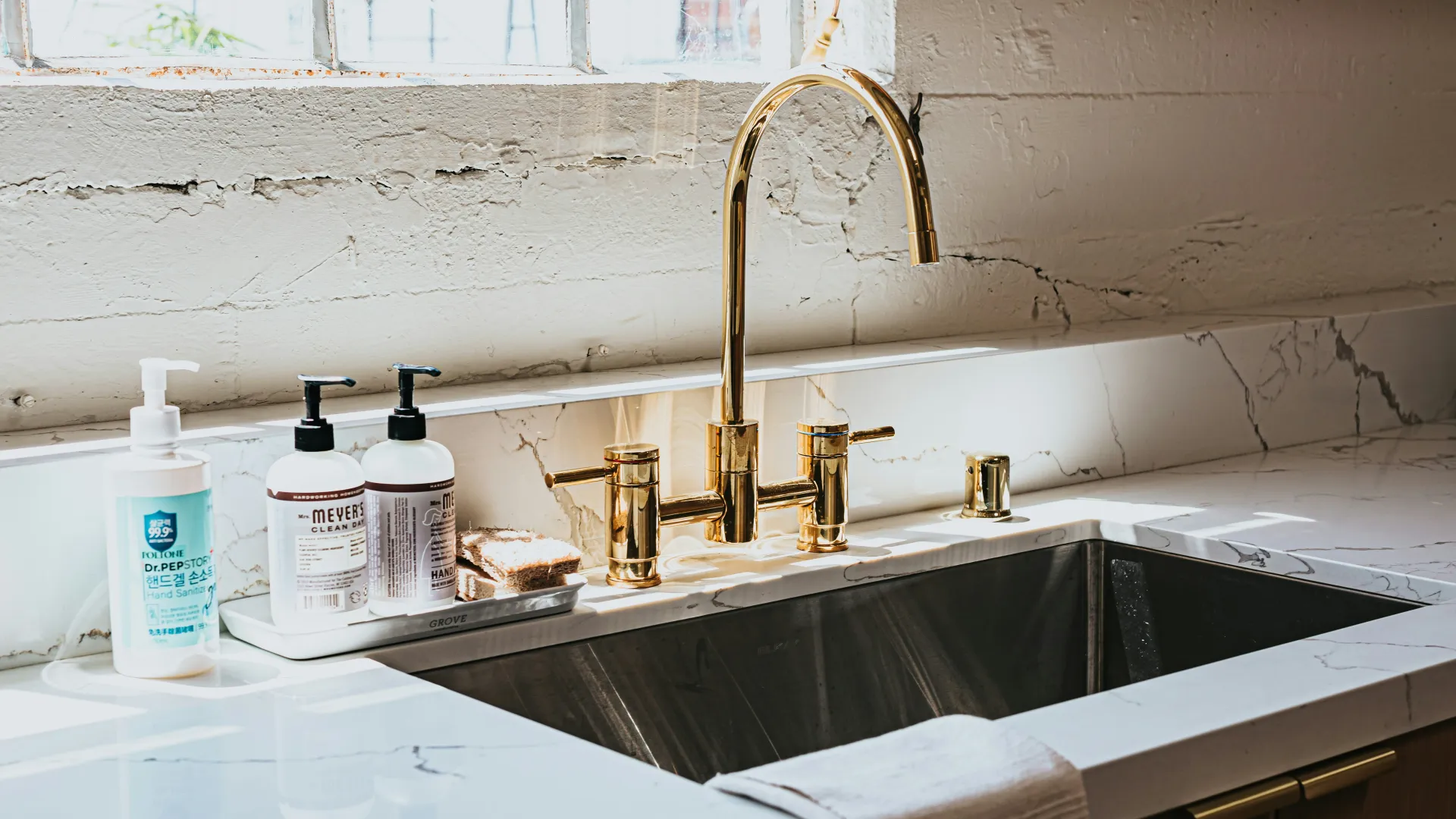 a sink with a faucet and bottles of soap