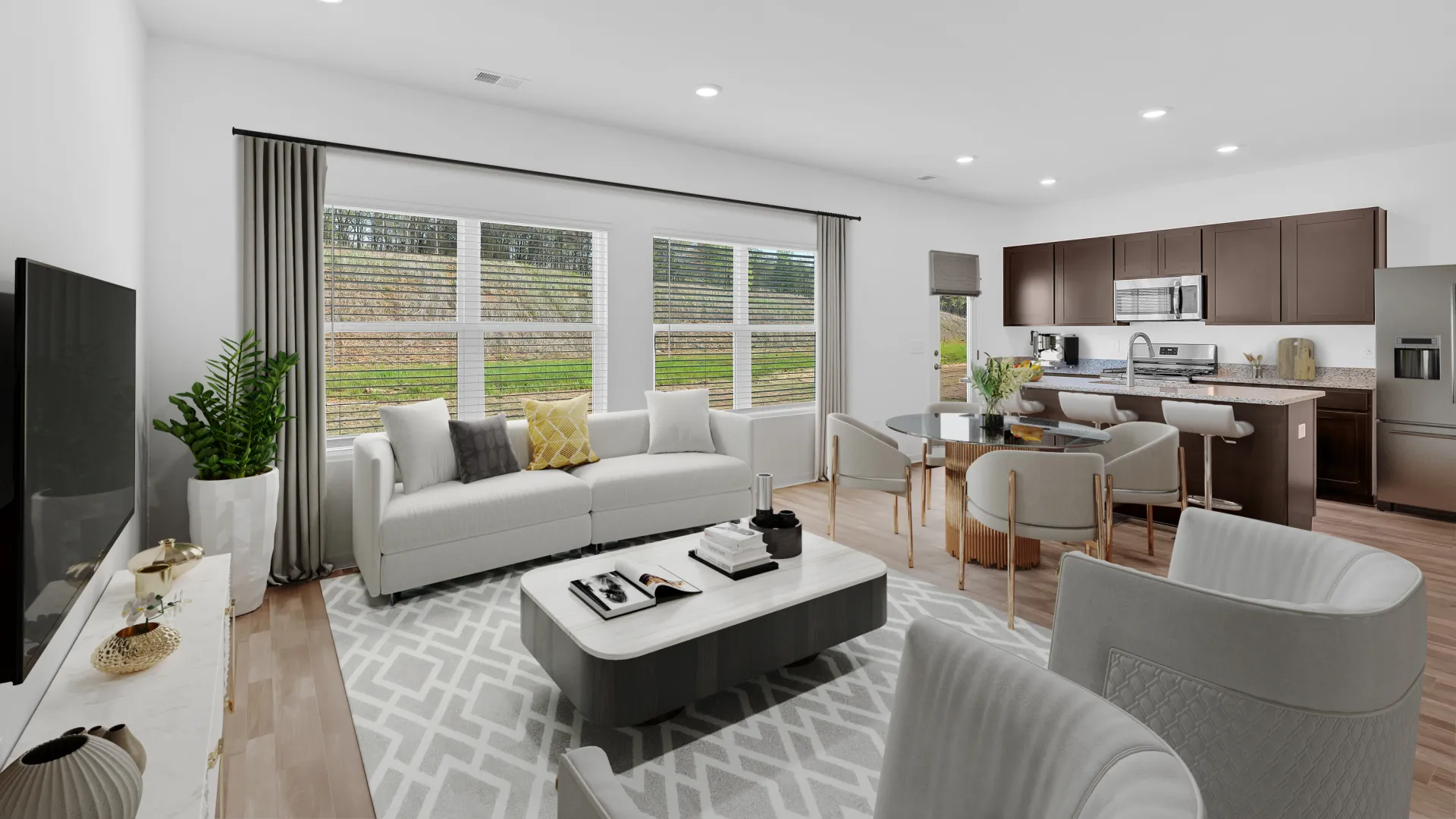 Modern living room with large windows, stylish furniture, and open kitchen design.