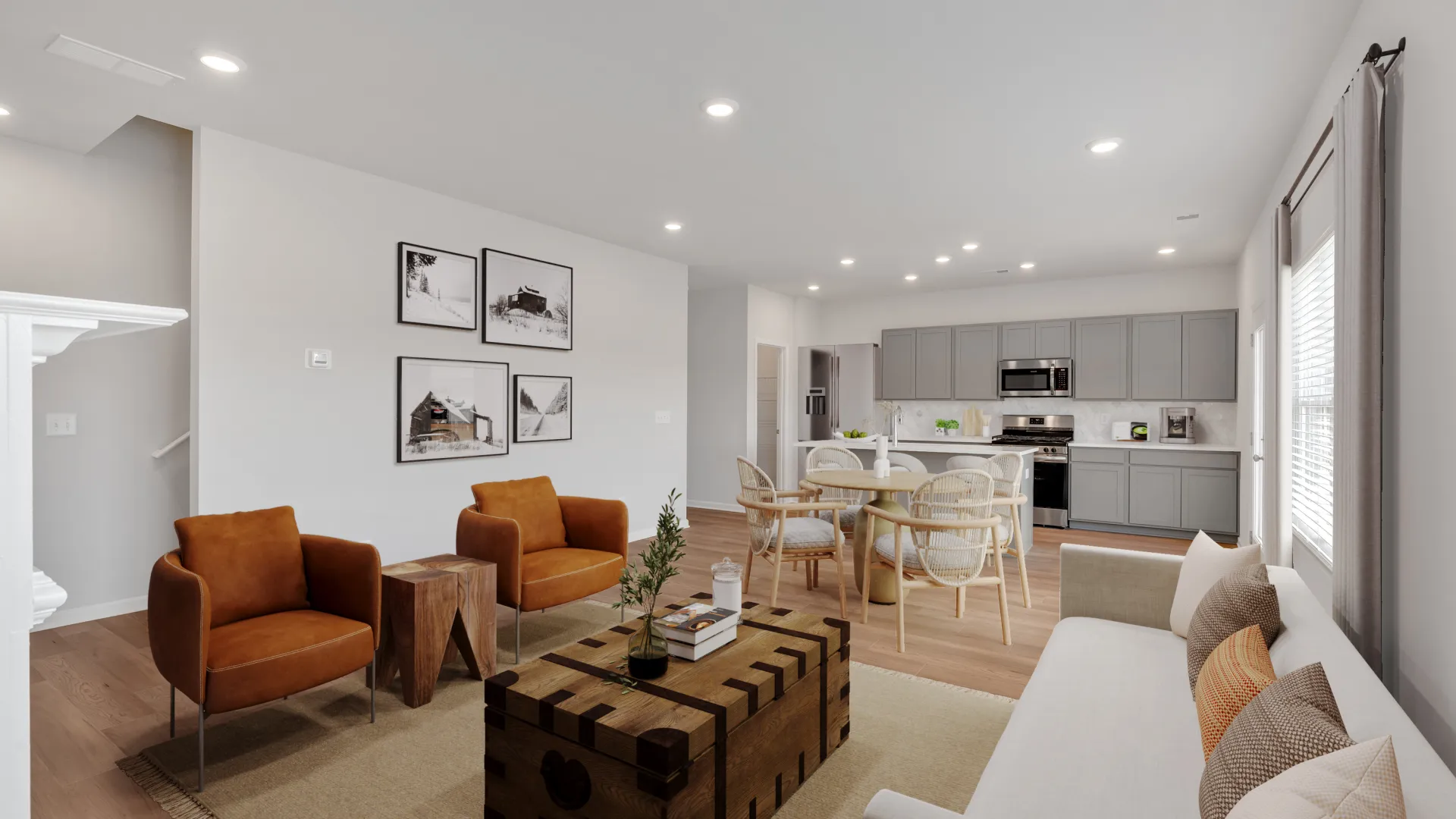 Bright open living room and kitchen with modern furniture, wood flooring, and neutral color palette