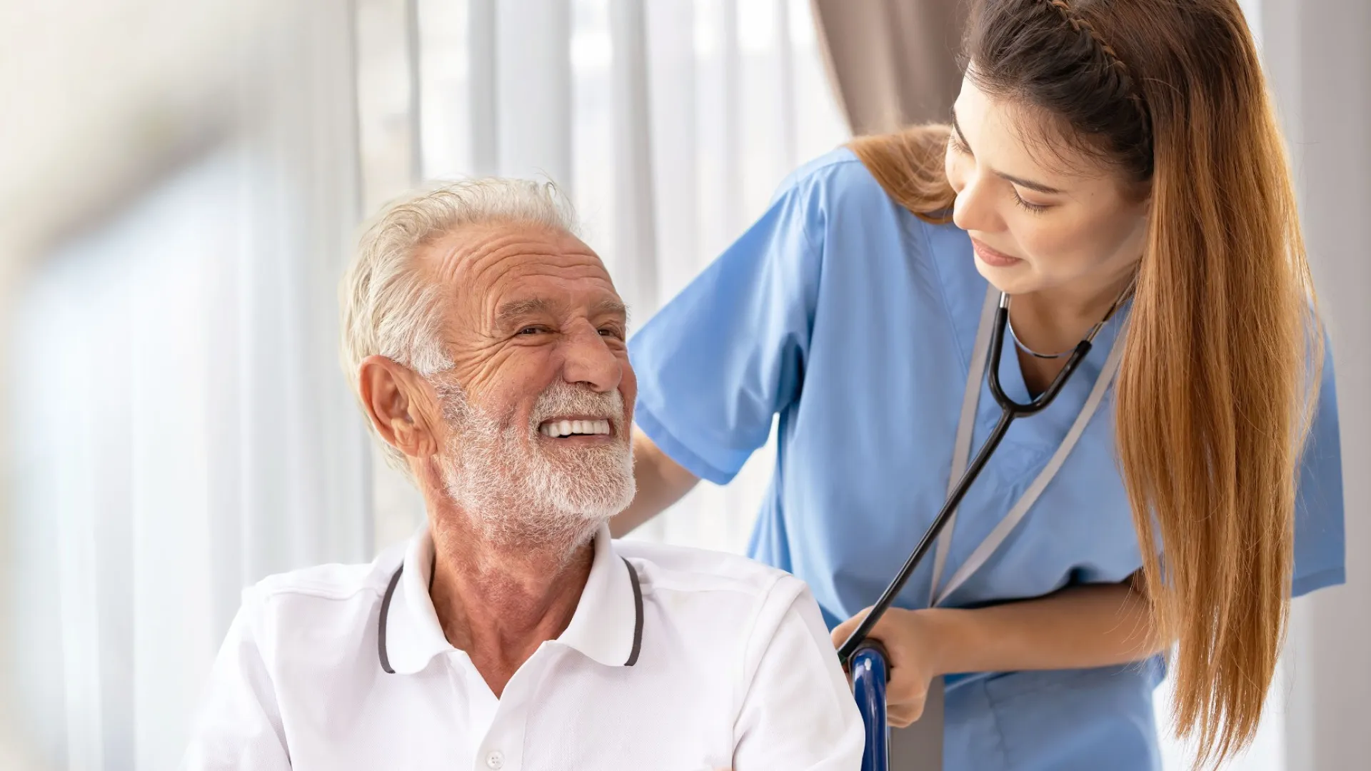 Smiling senior man with a nurse, discussing health in a bright medical setting.