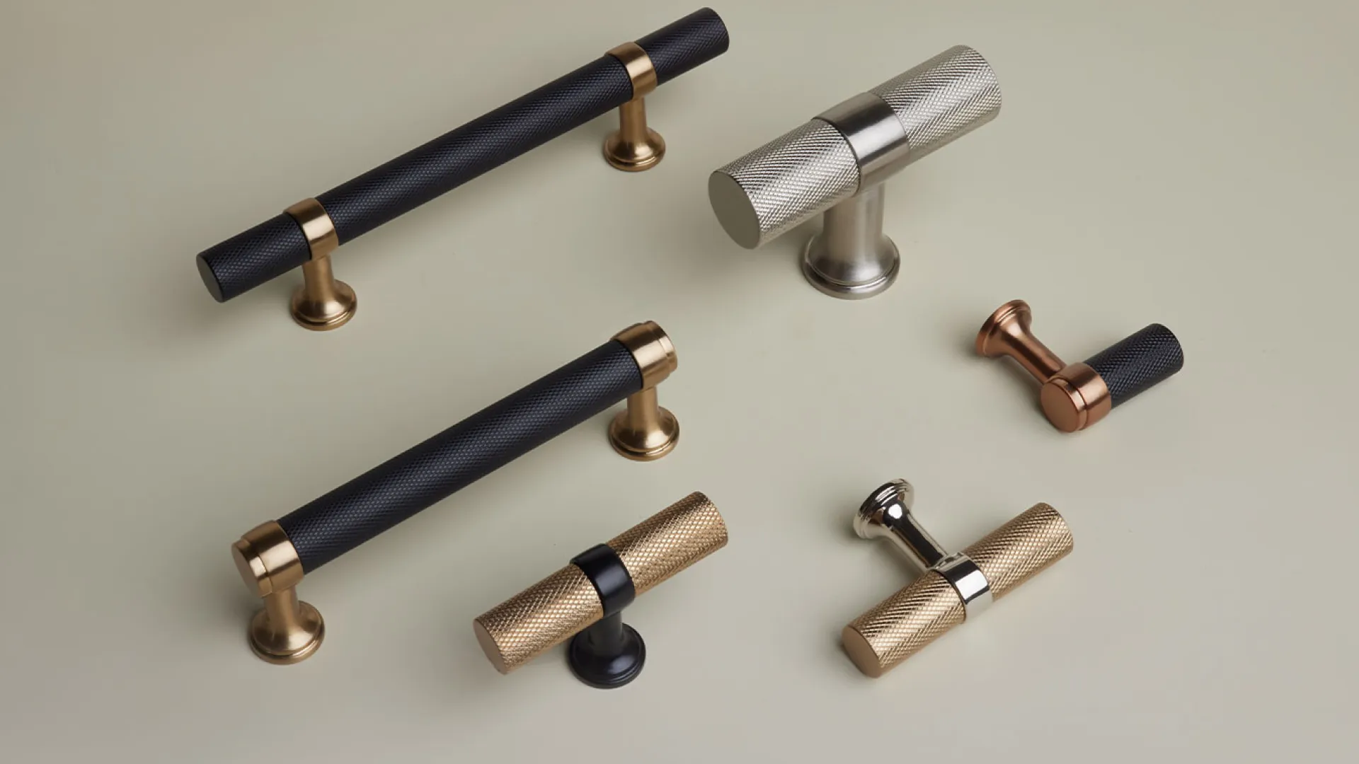 Variety of modern metal cabinet handles and knobs in black, bronze, silver, and gold finishes on a beige background.