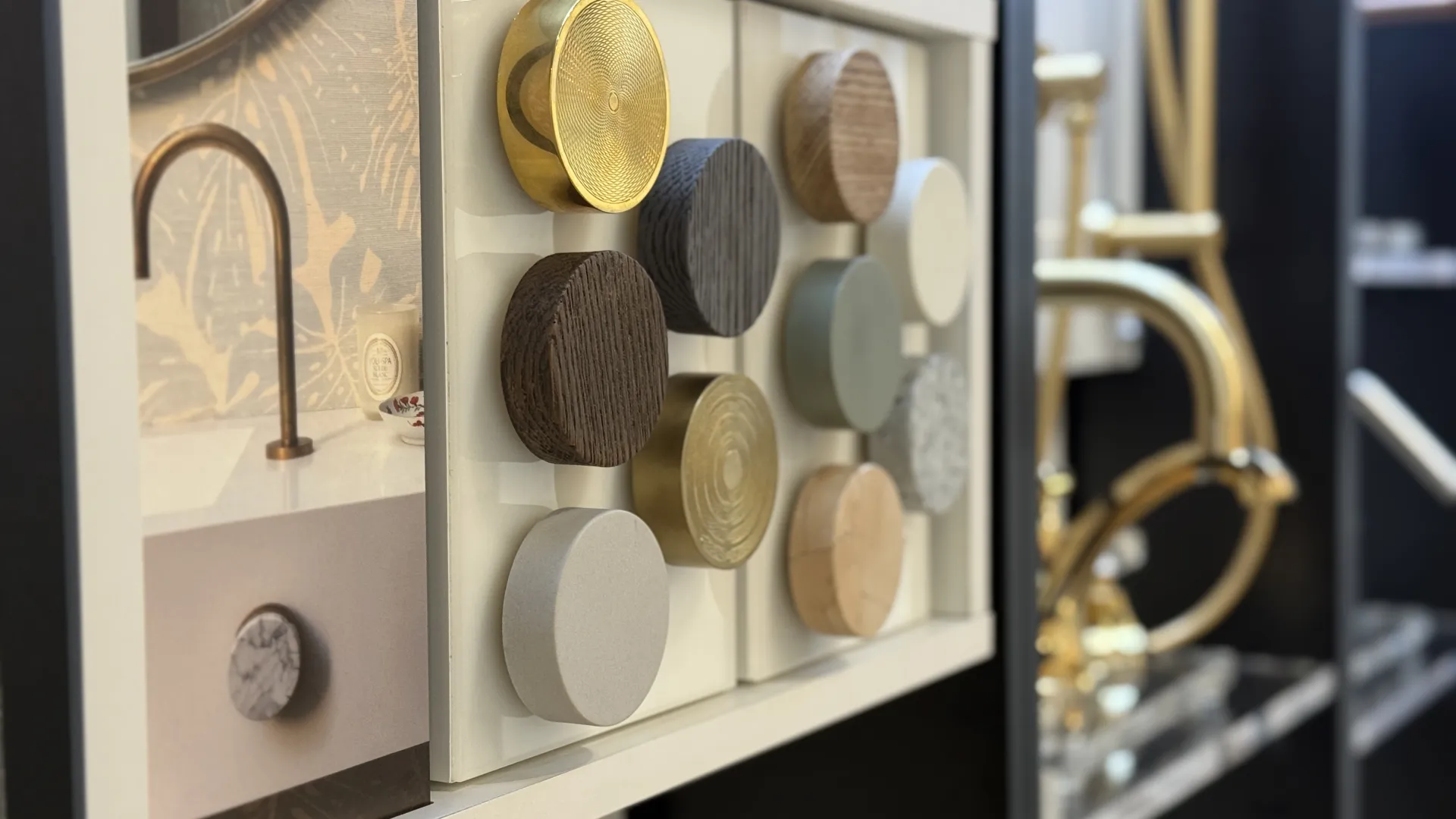 Samples of round cabinet knobs in various finishes including wood, metal, and stone displayed on a board.
