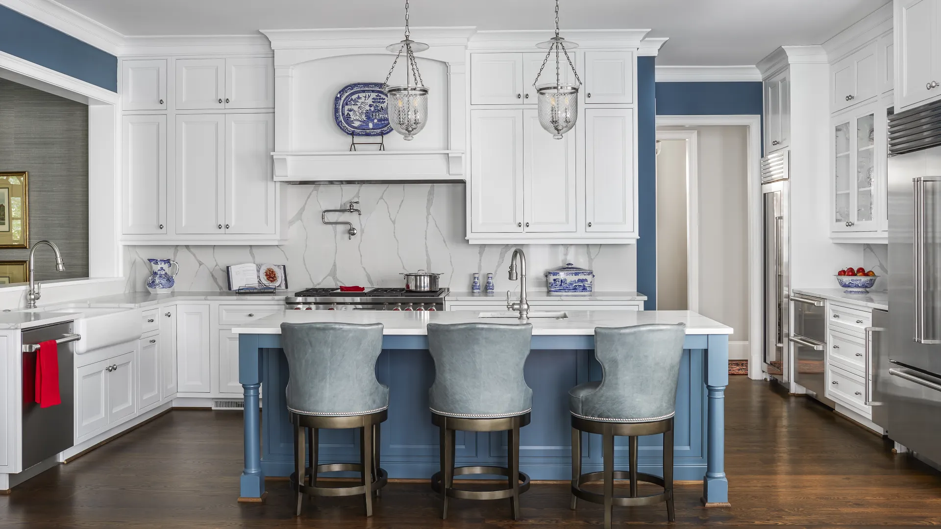 Modern kitchen featuring an island, white cabinetry, stylish lighting, and elegant decor elements.