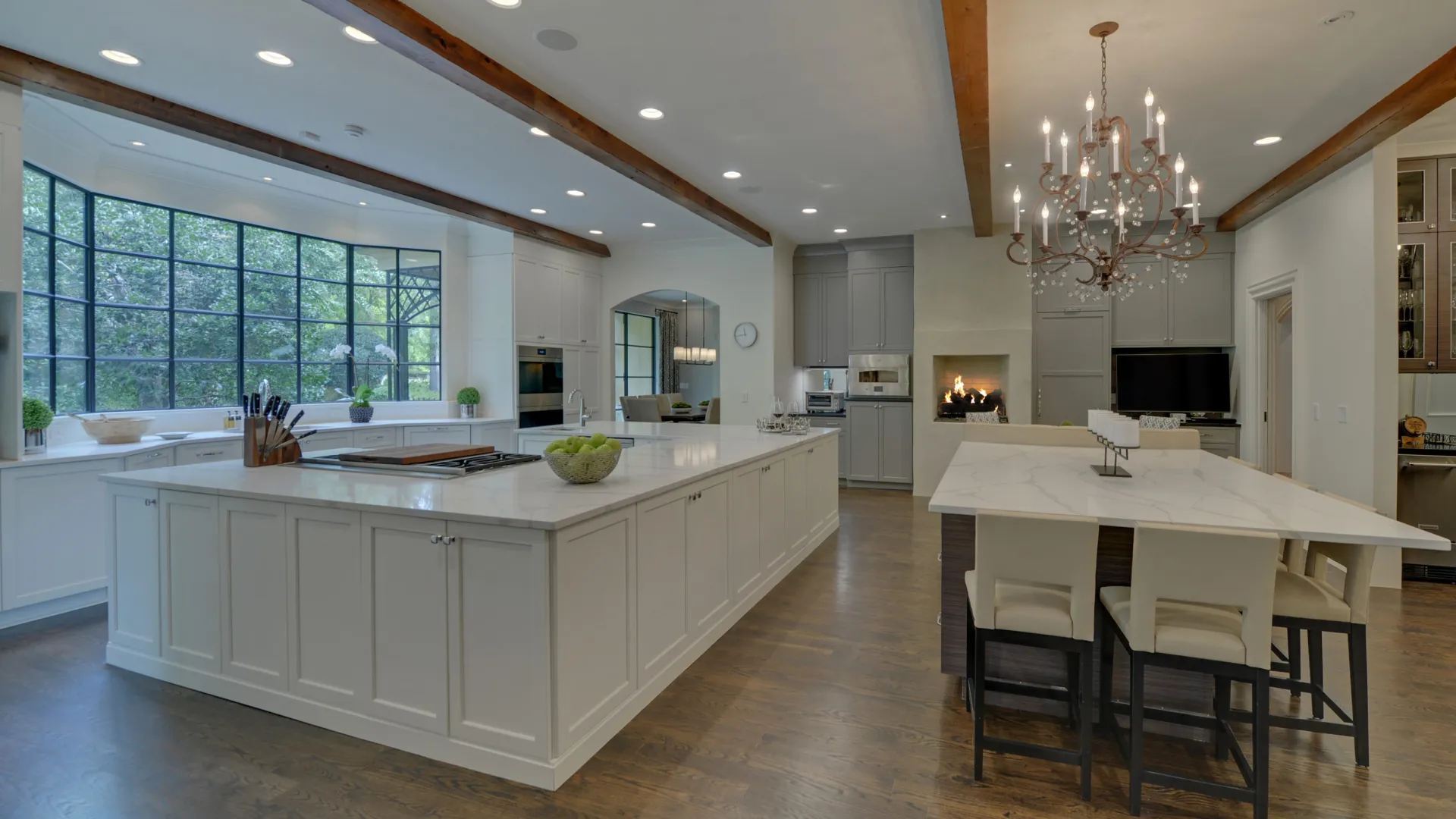 Modern kitchen featuring an island, white cabinetry, stylish lighting, and elegant decor elements.