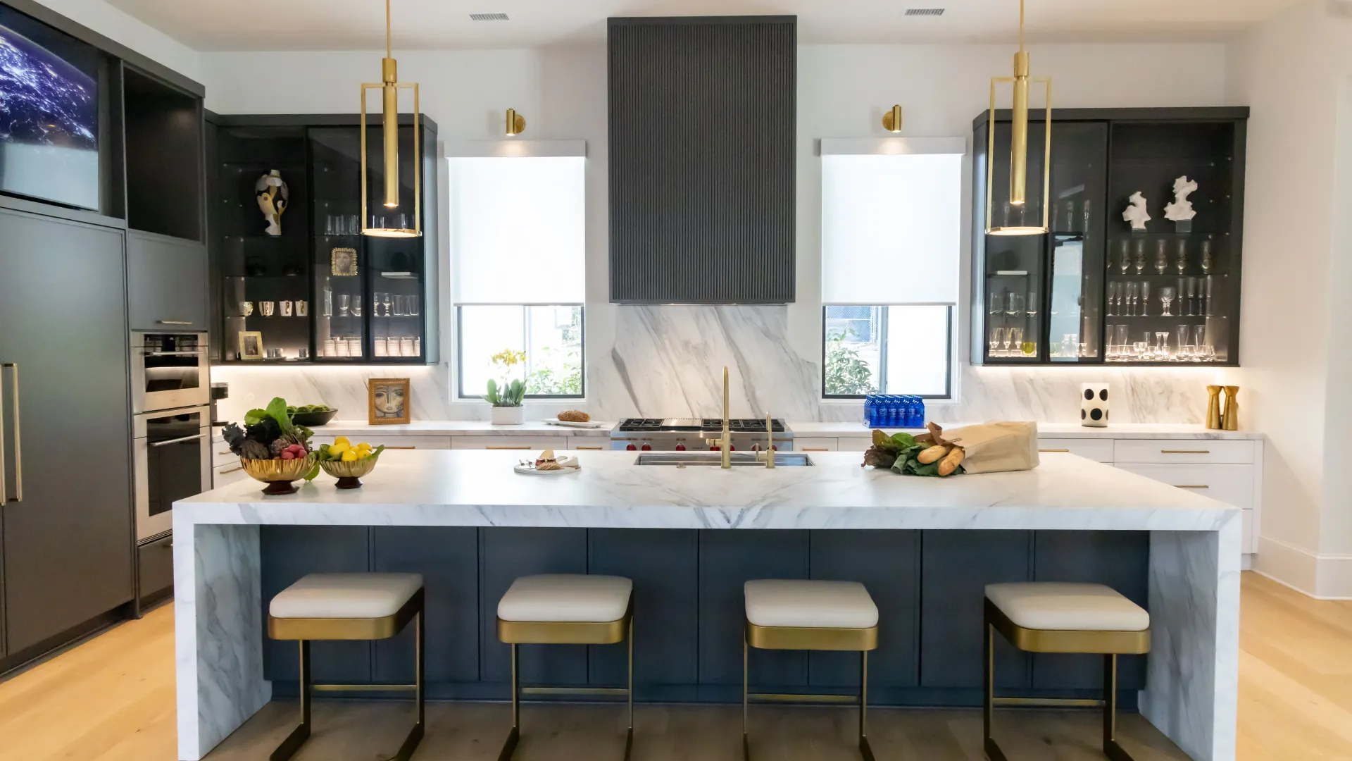 Modern kitchen featuring an island, white cabinetry, stylish lighting, and elegant decor elements.