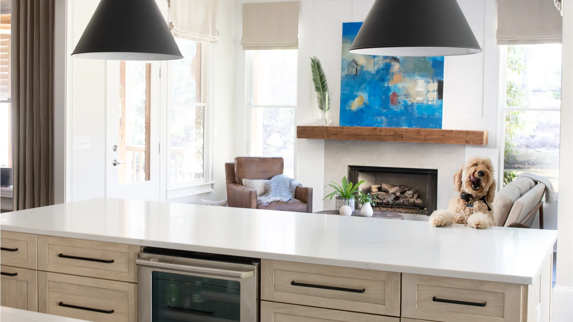 Modern kitchen featuring an island, white cabinetry, stylish lighting, and elegant decor elements.