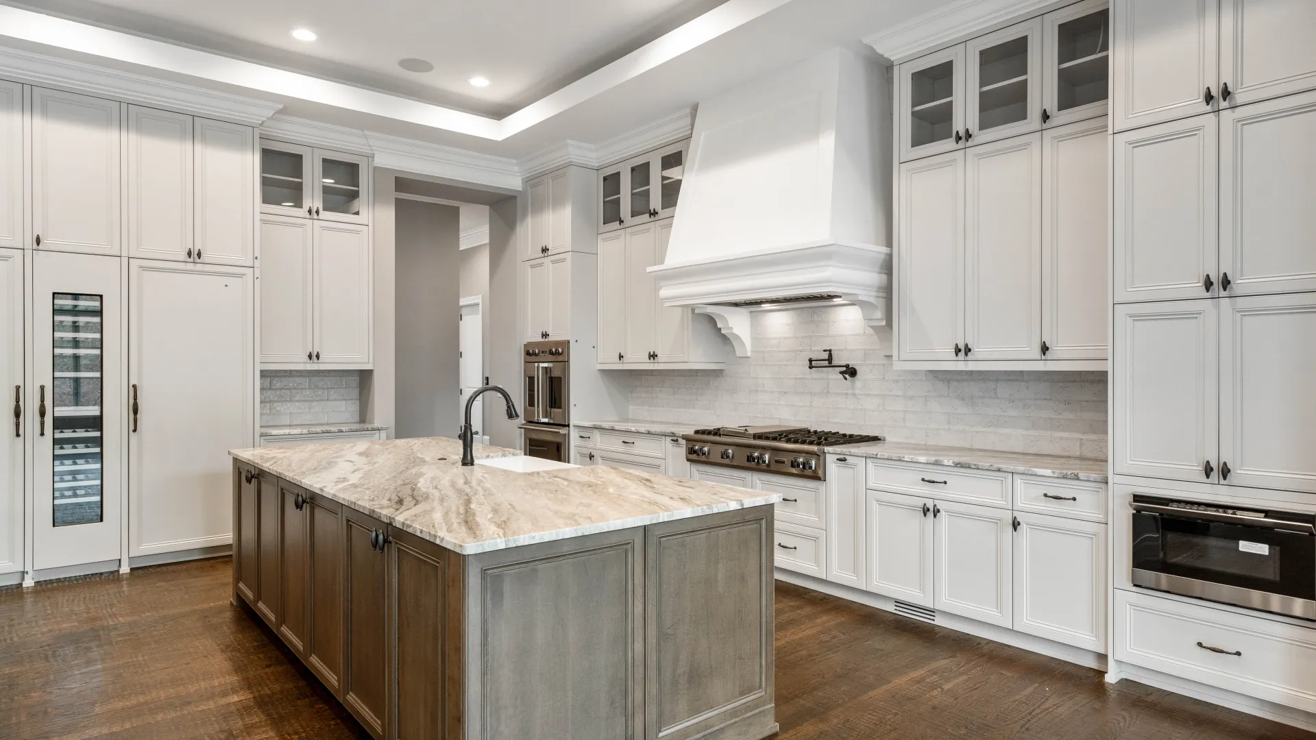 Modern kitchen featuring white cabinetry, granite countertops, and hardwood flooring.