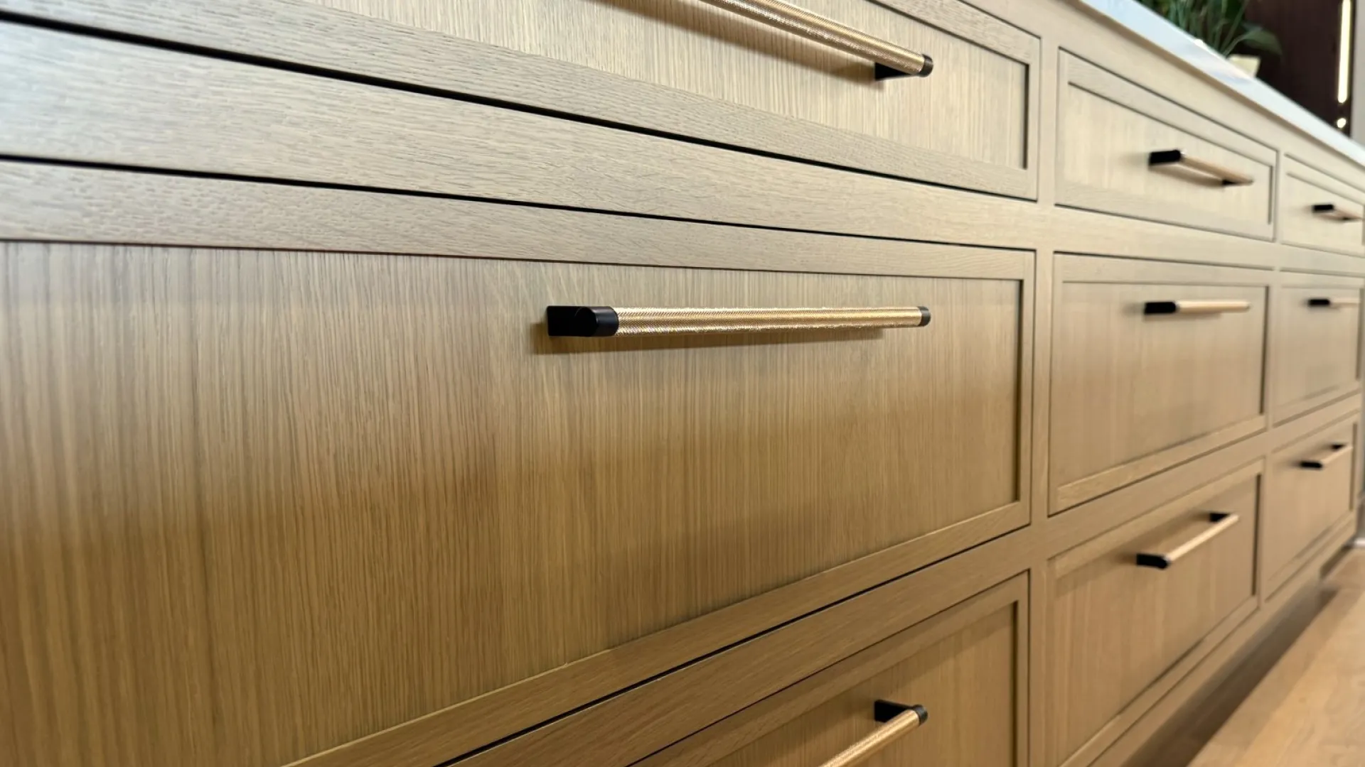 Modern wooden kitchen cabinets with sleek horizontal handles in a light oak finish.