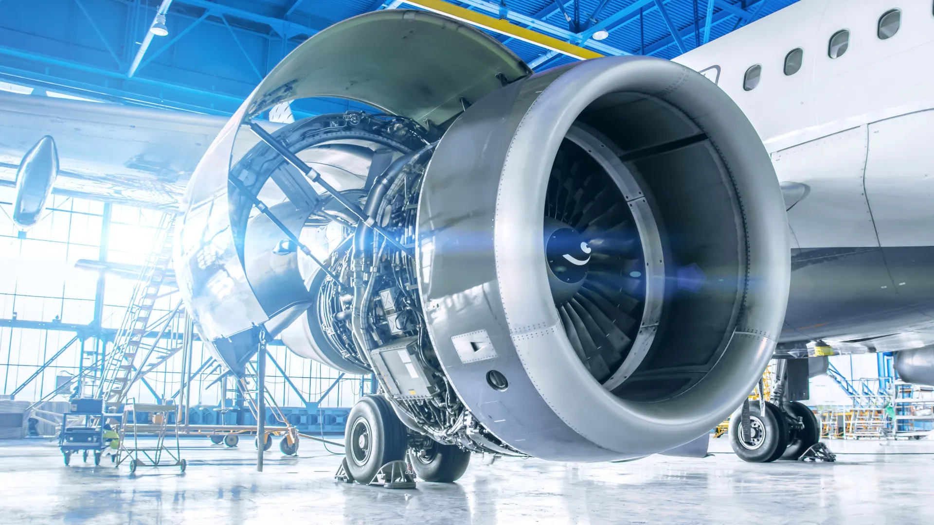 Close-up of a detailed aircraft jet engine in a well-lit hangar setting.
