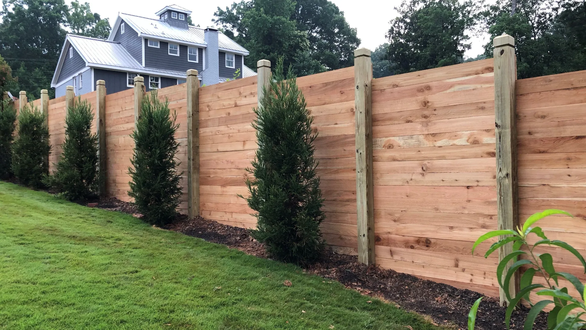 a fenced in yard with a house in the background