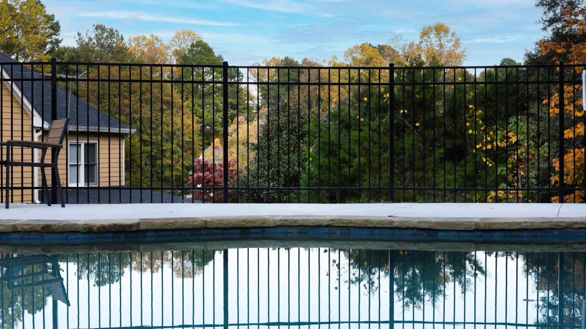 a house with a pool and trees in the back