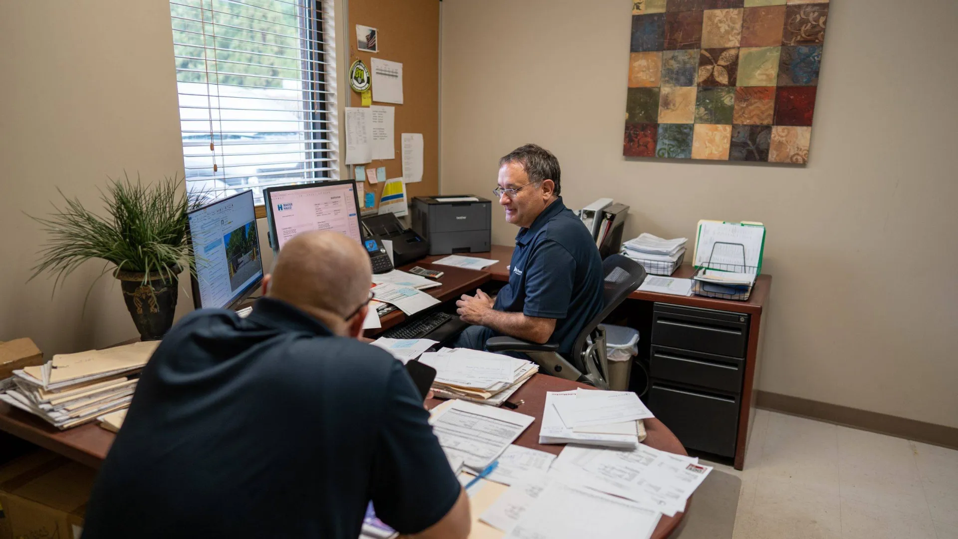 men sitting at a desk with computers