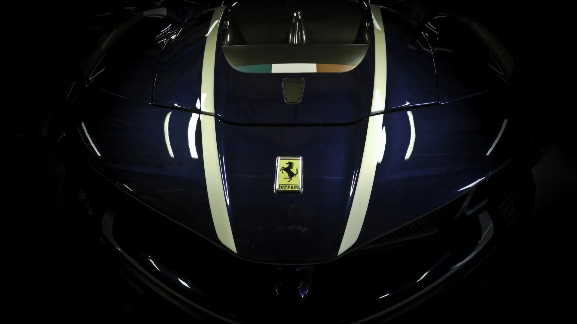 Sleek blue Ferrari design with dual white racing stripes against a dark background.