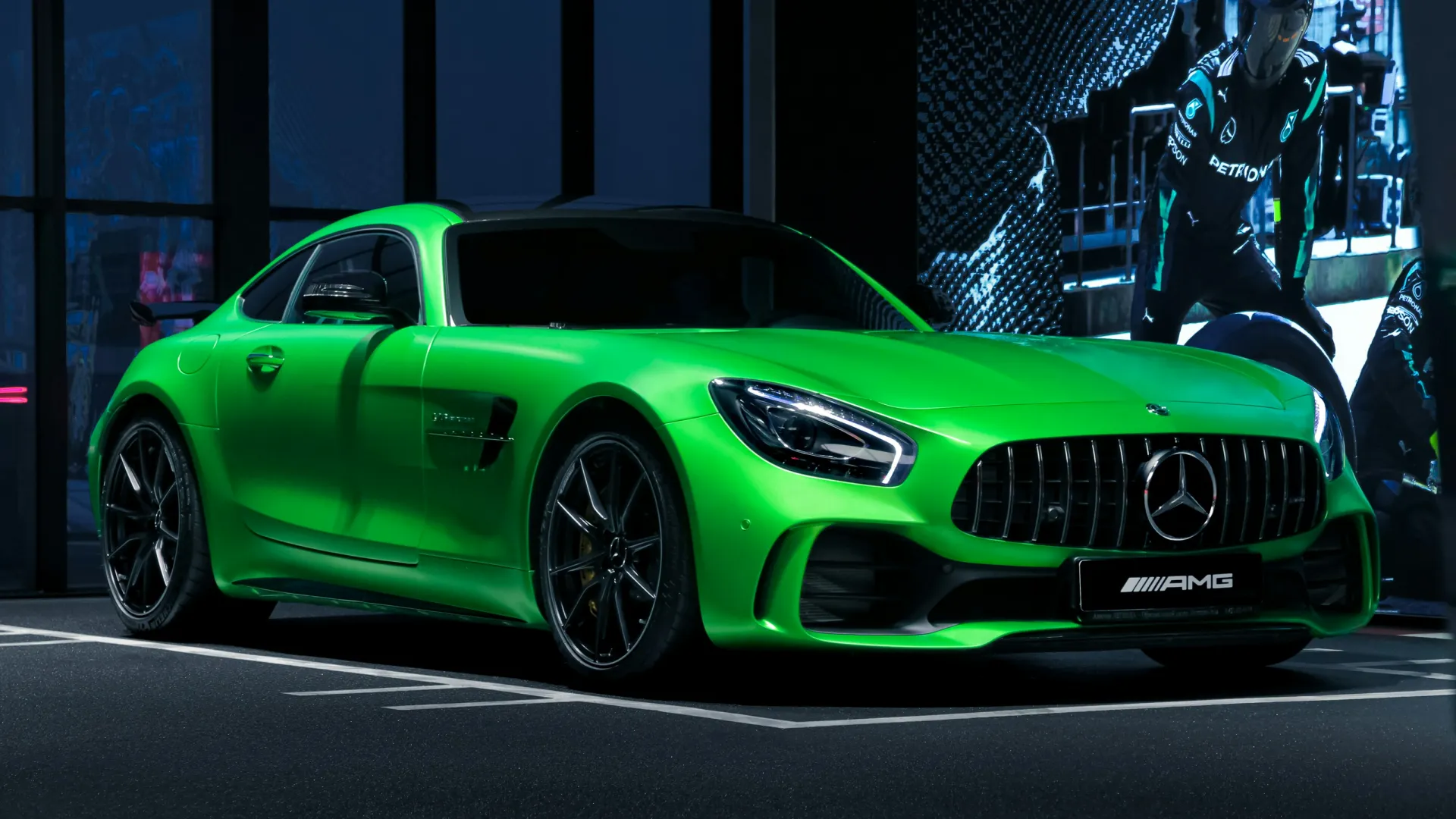 Vibrant green Mercedes AMG sports car parked indoors with sleek design and black wheels.
