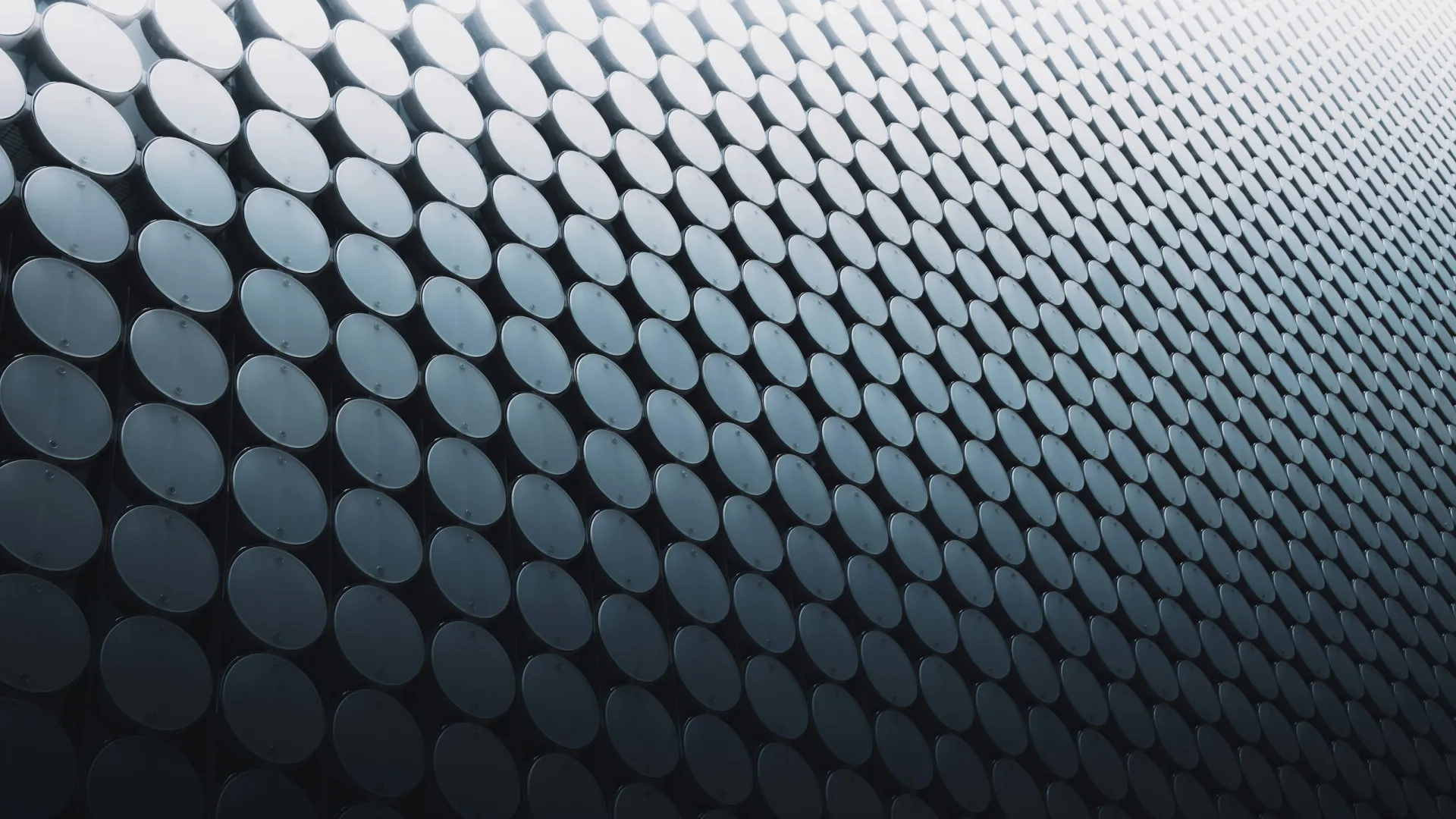 Curved building façade covered with reflective circular discs creating a futuristic pattern.