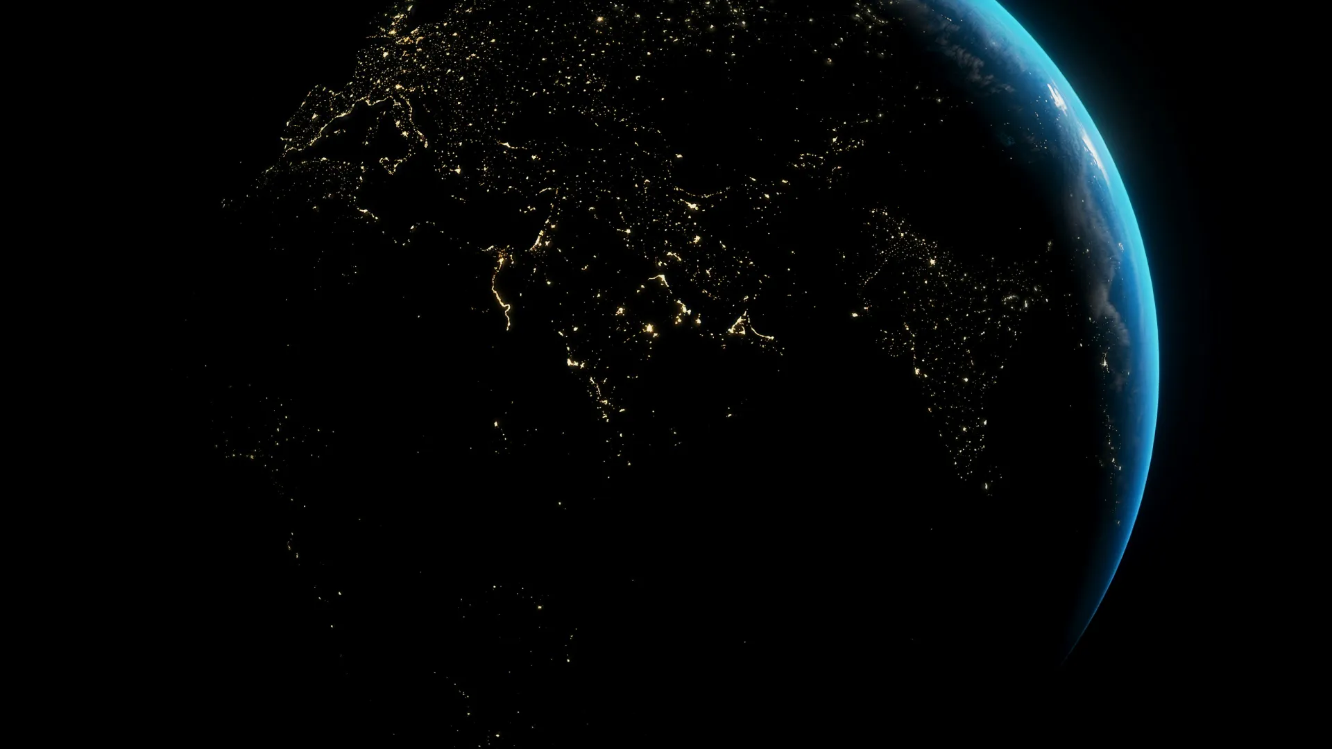 View of Earth at night showing illuminated cities and blue atmospheric glow on the horizon.