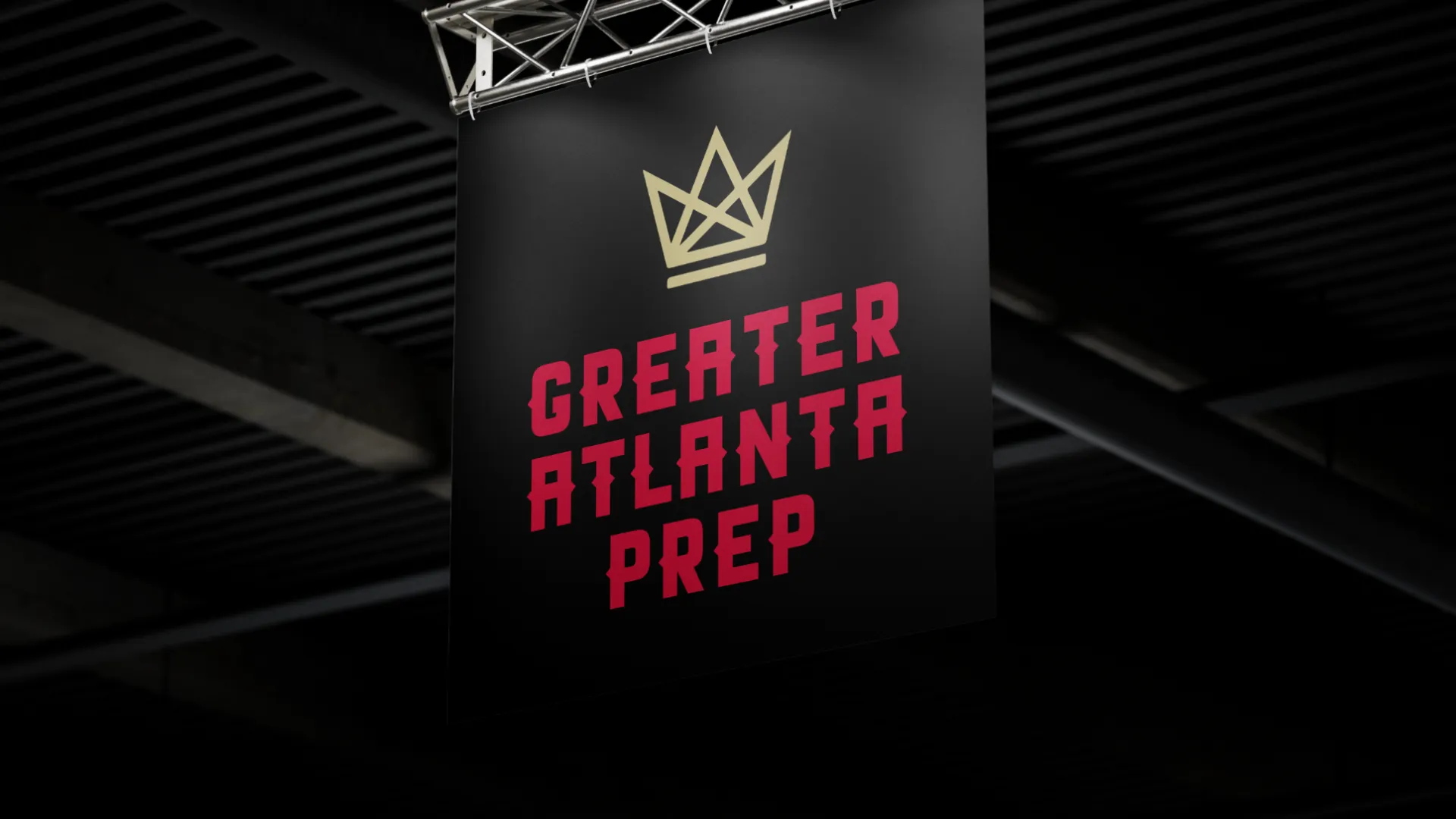Black banner with gold crown logo and red text saying Greater Atlanta Prep hanging indoors under ceiling lights.