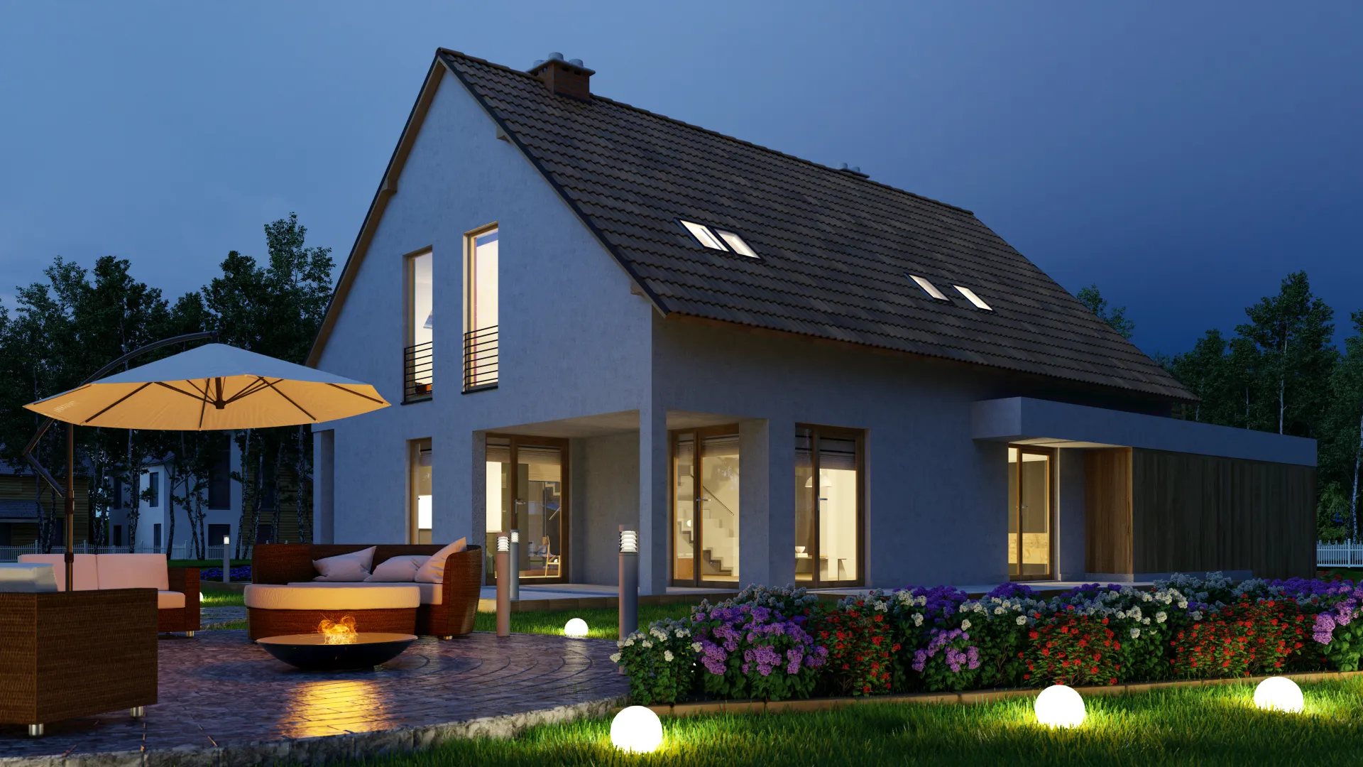 Modern two-story house at night with outdoor seating and garden lights, surrounded by greenery and flowers.