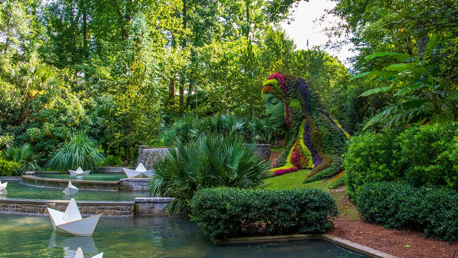 a pond with a statue in the middle of it