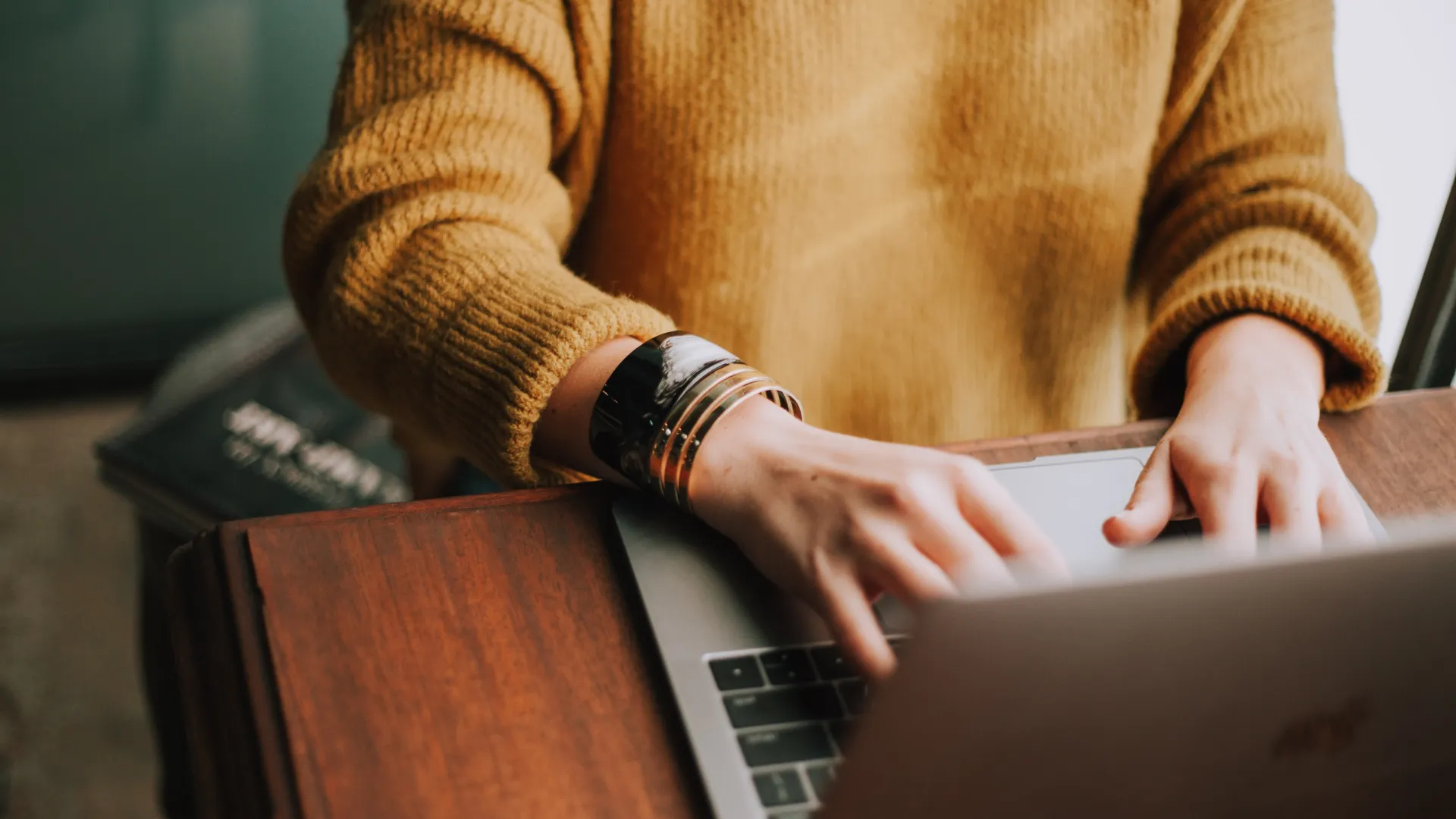 a hand pointing at a laptop