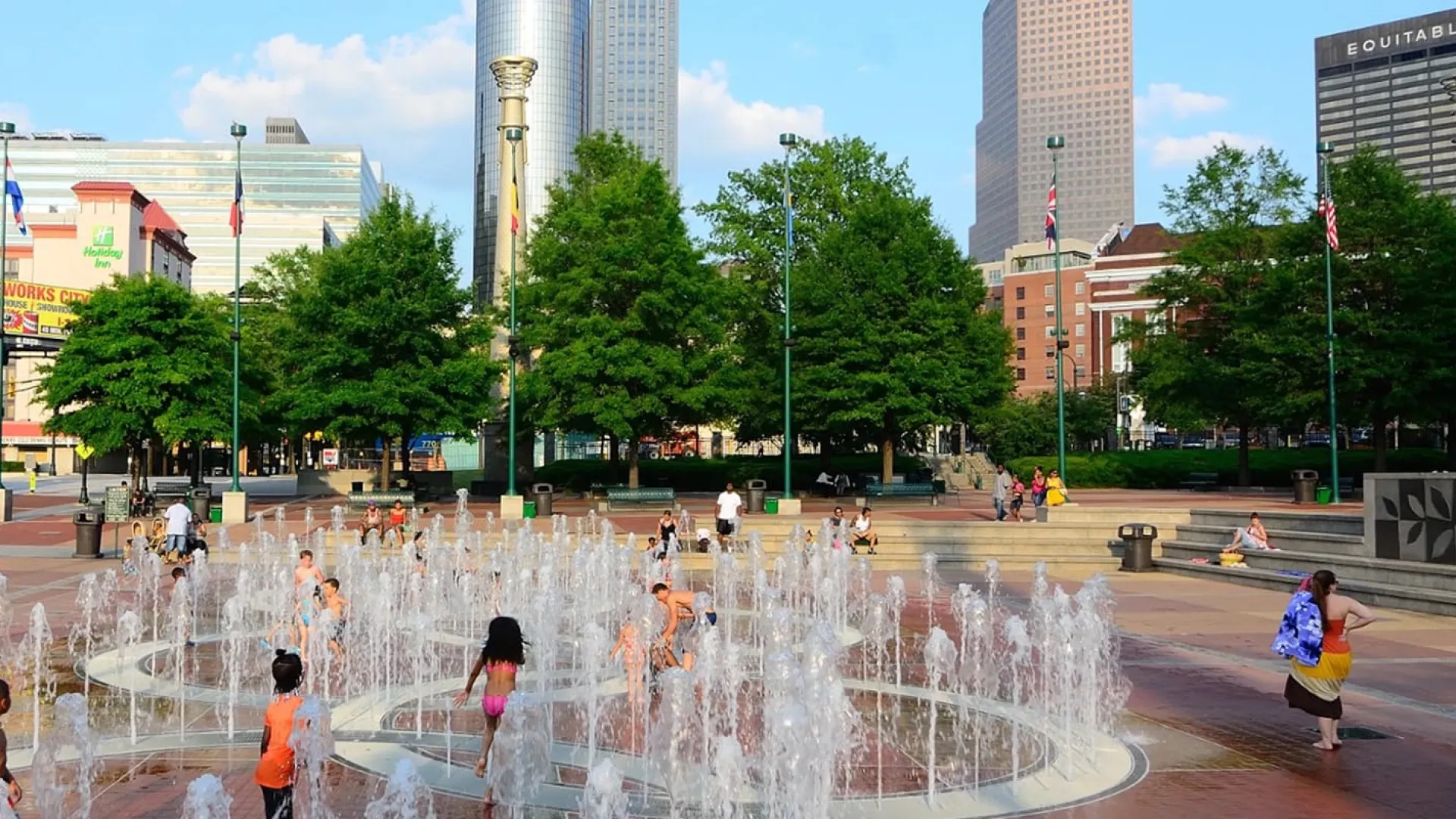 a group of people playing in a water fountain in Centennial Olympic Park