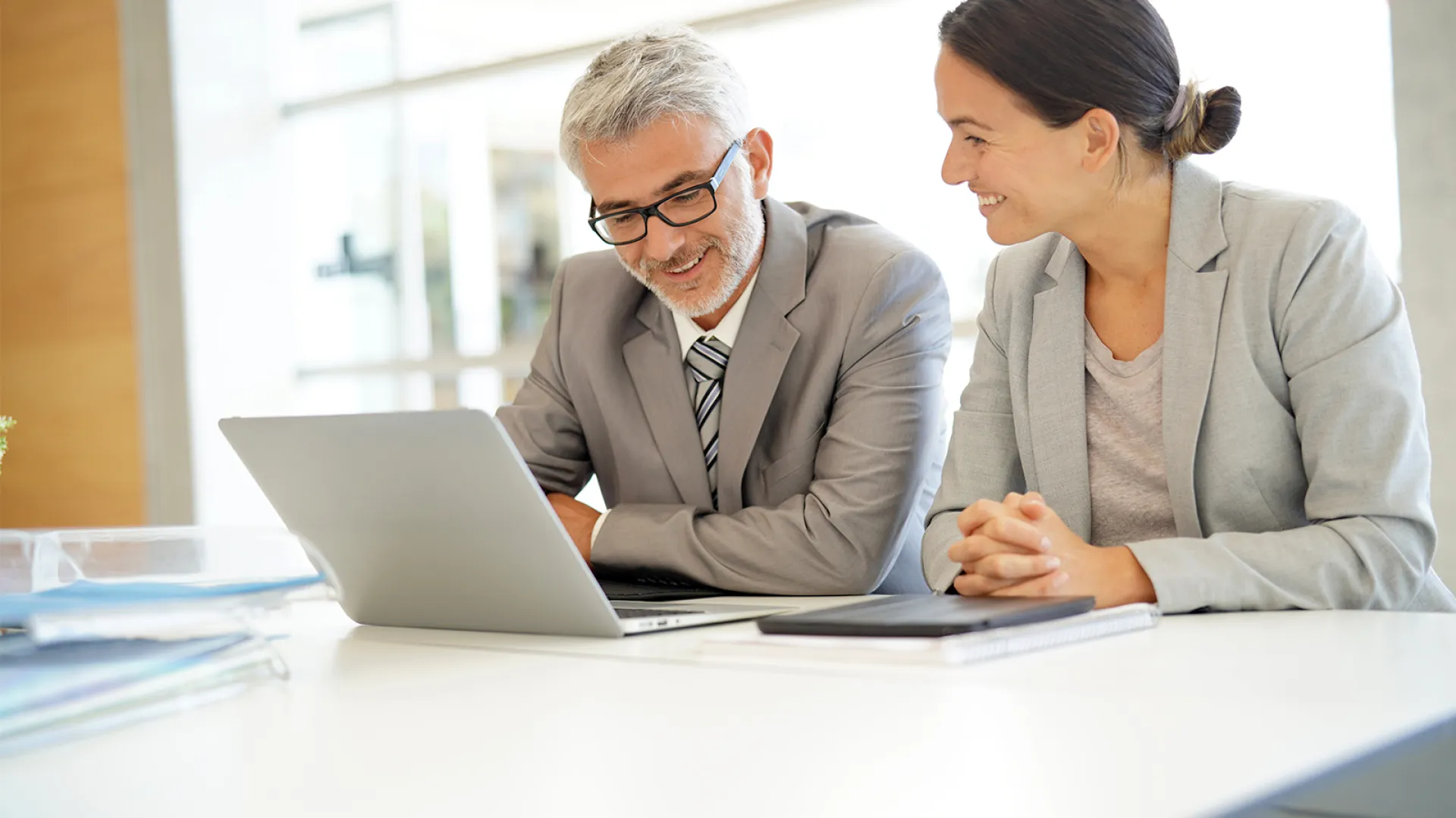 two people looking at a laptop