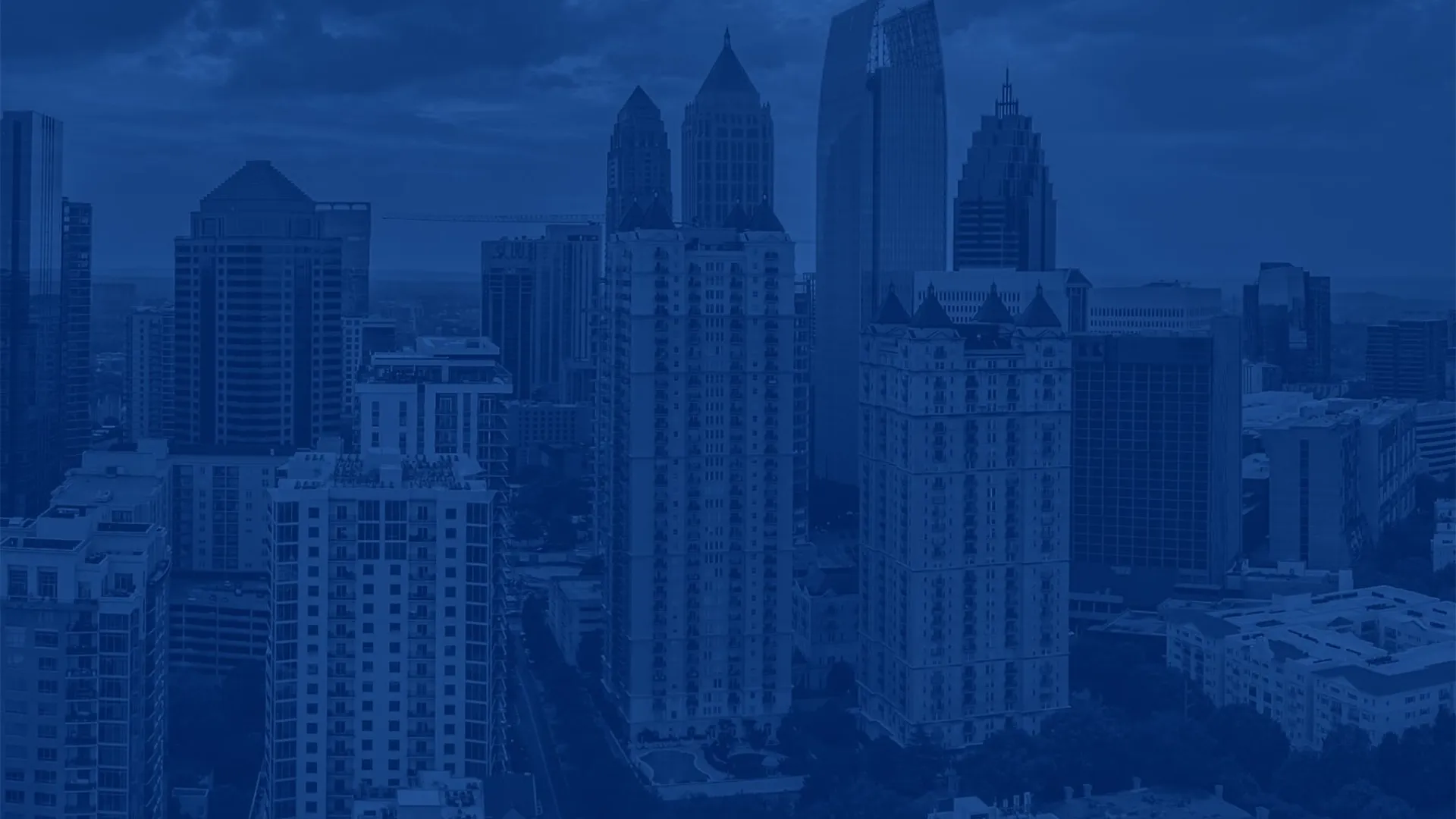 City skyline with tall skyscrapers and residential buildings under a cloudy sky during daytime