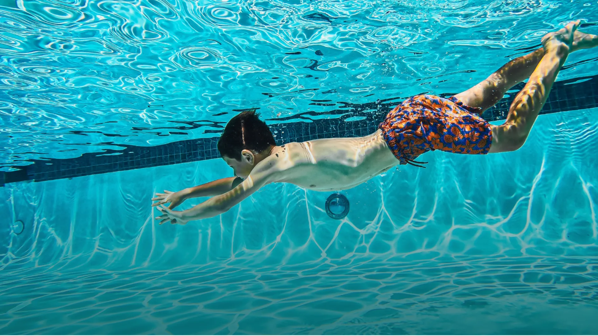 a boy swimming in a pool