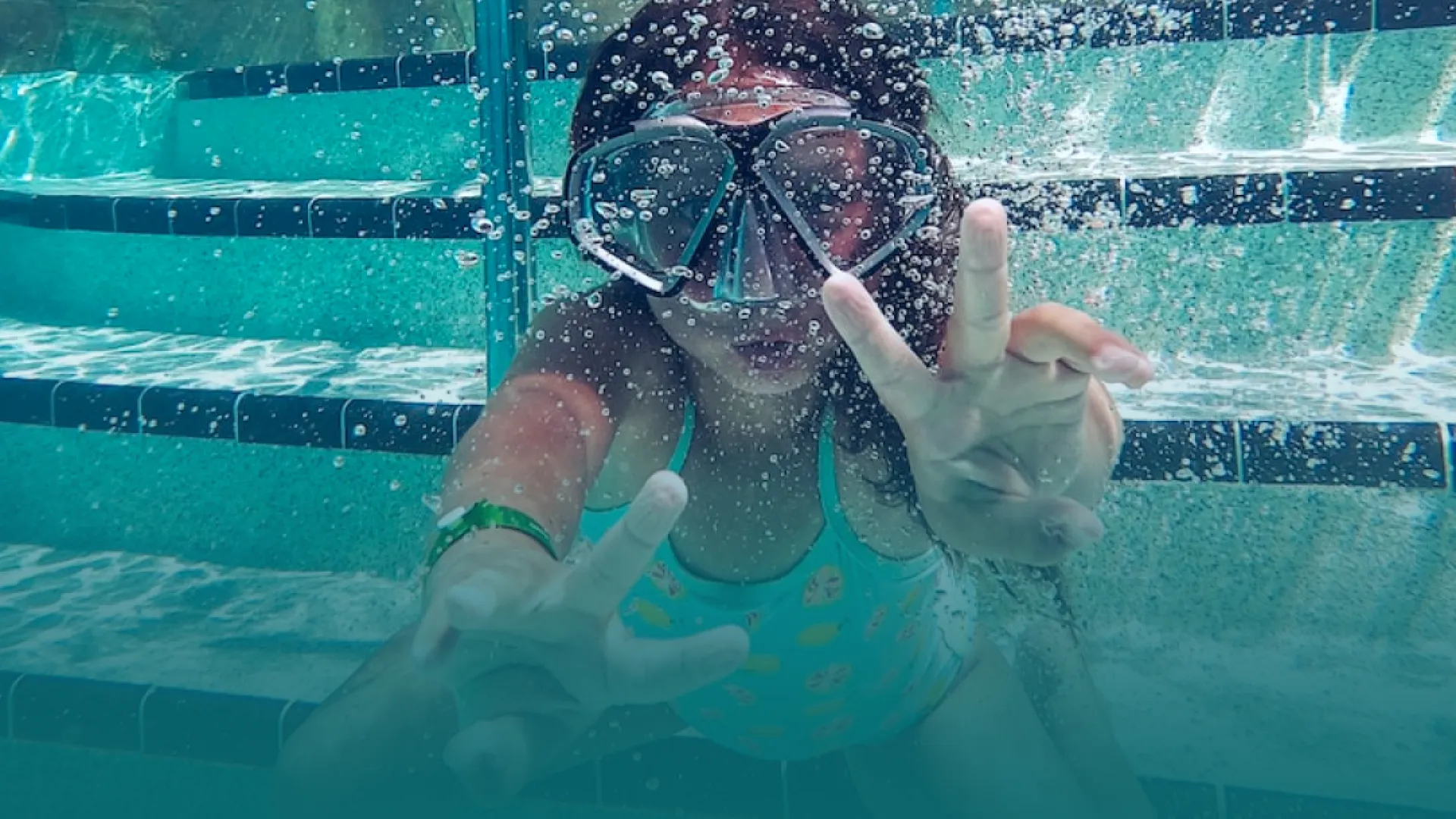 a person in a pool wearing goggles and a diving suit