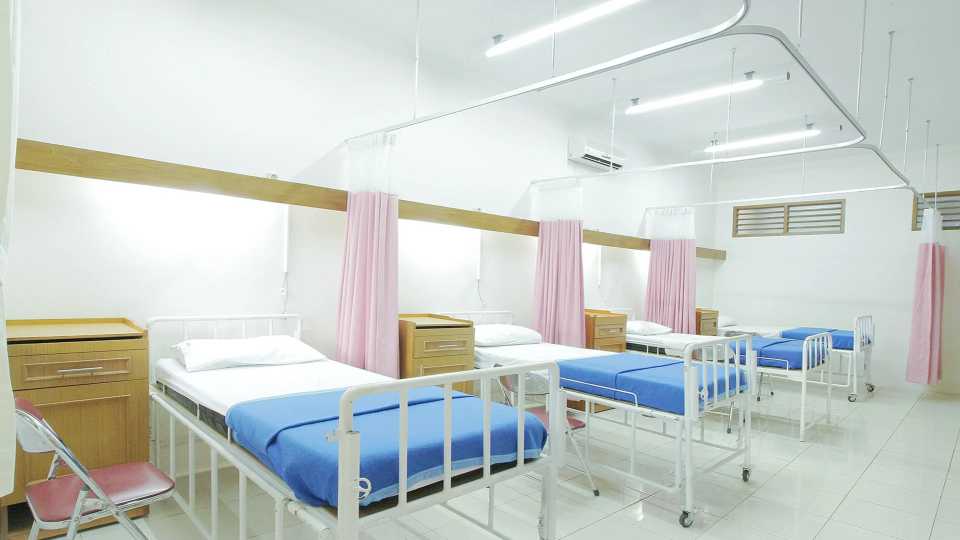 a hospital room with beds and chairs