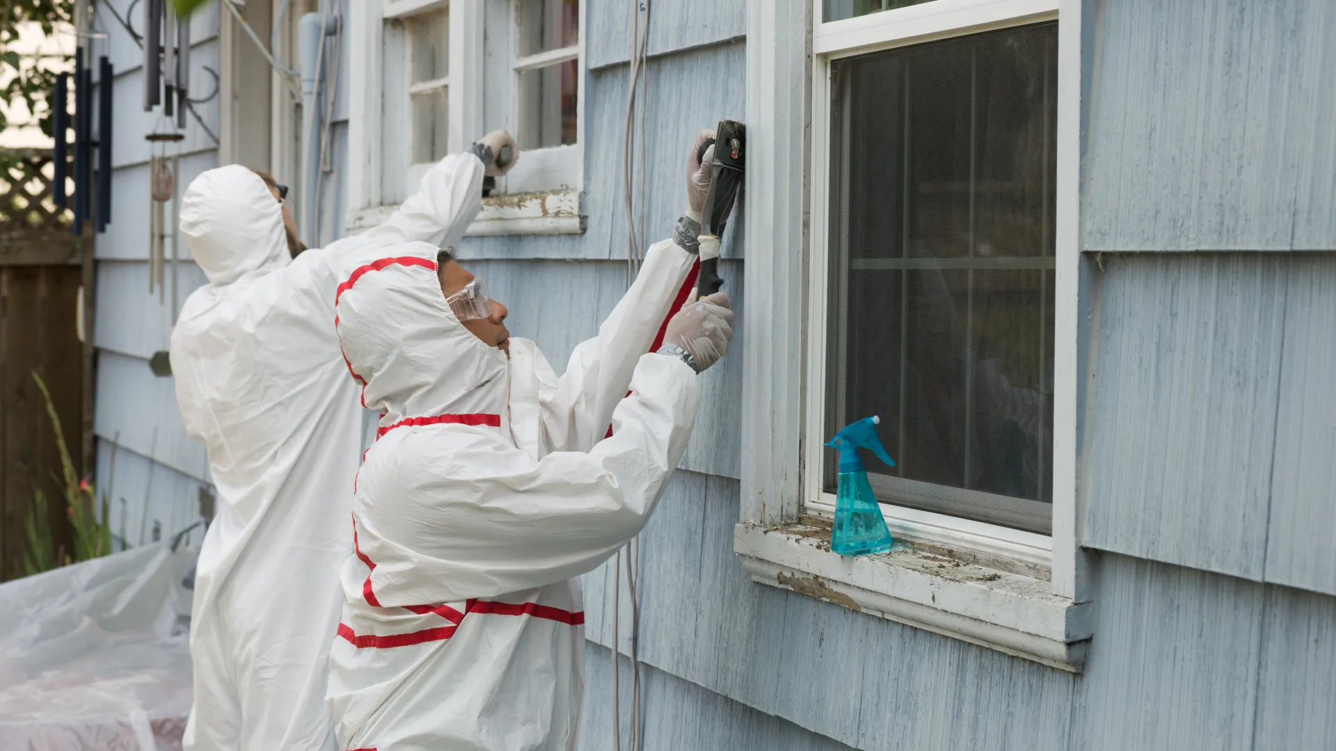 a person in a white suit cleaning a house