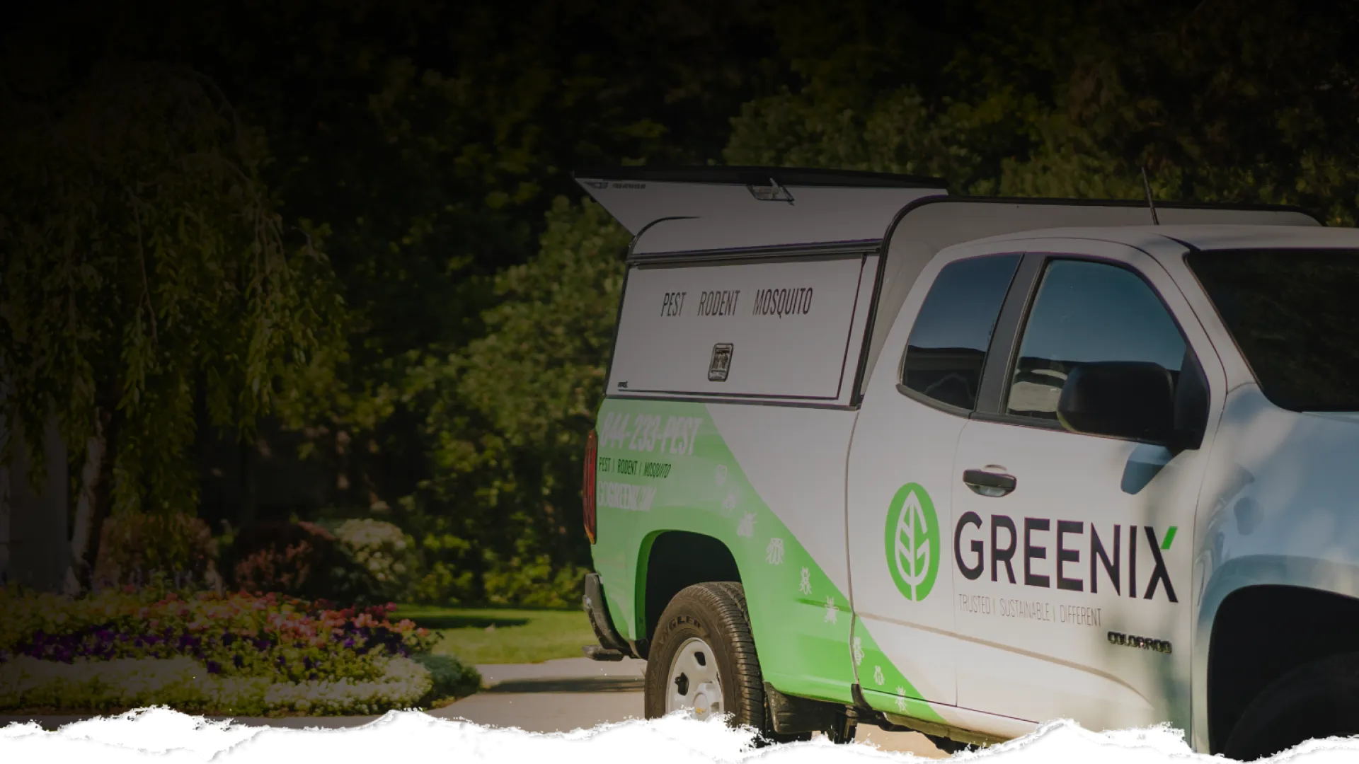 Greenix pest control truck parked with branding for pest, rodent, and mosquito services in a suburban neighborhood.