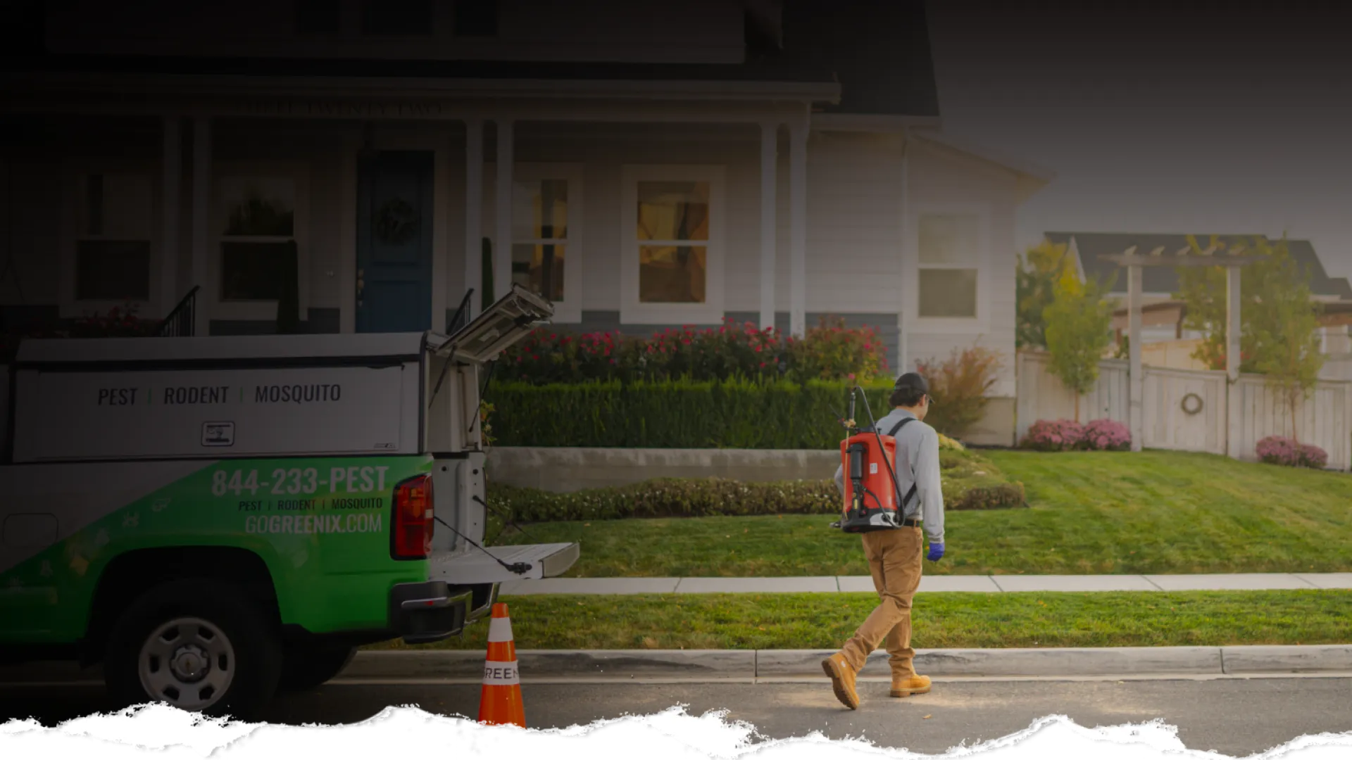 Pest control technician walking on street with equipment near green and white service truck in front of house.