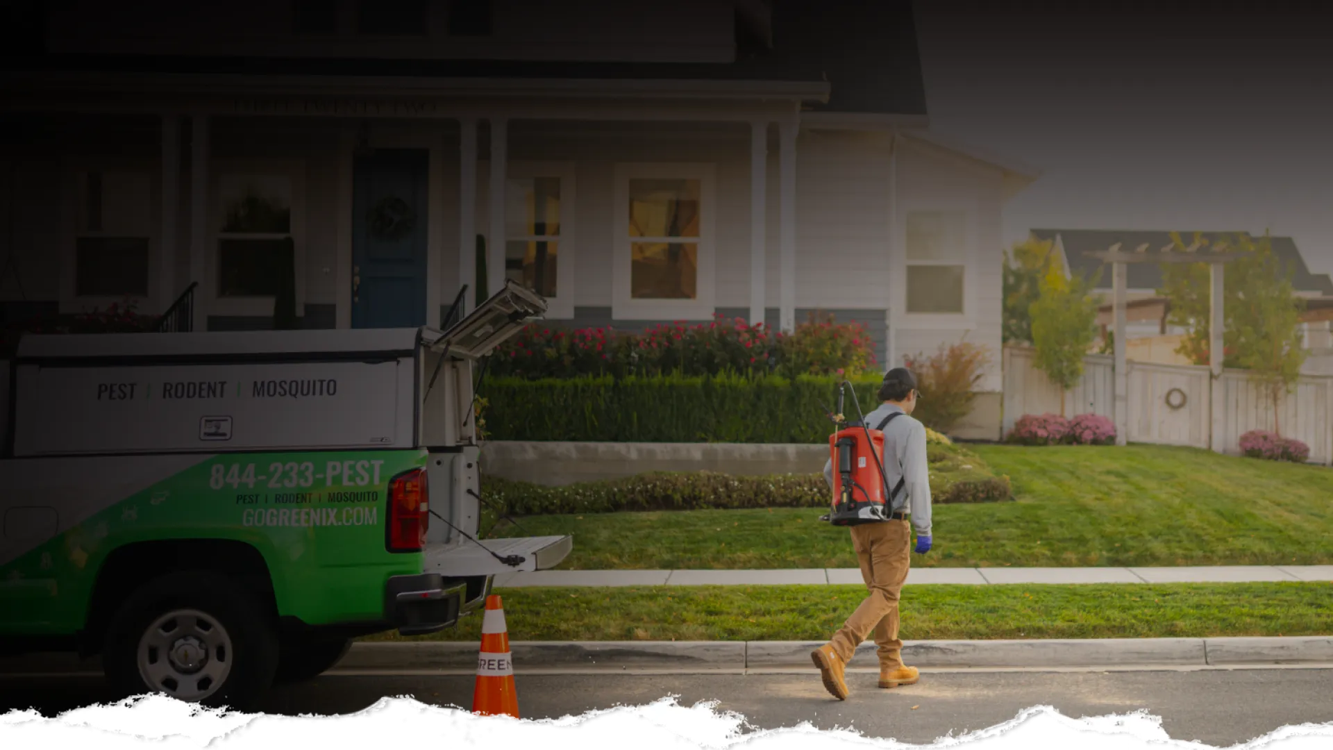 Pest control technician walking on street with equipment near green and white service truck in front of house.