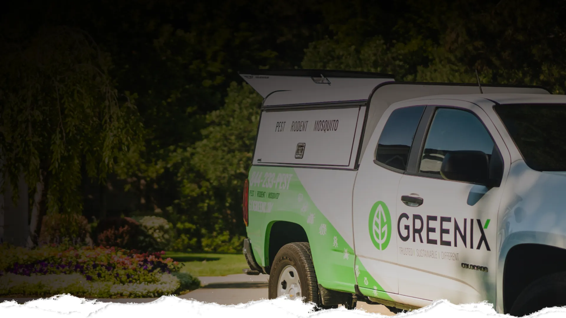 Greenix pest control truck parked outdoors with company logo and contact information visible