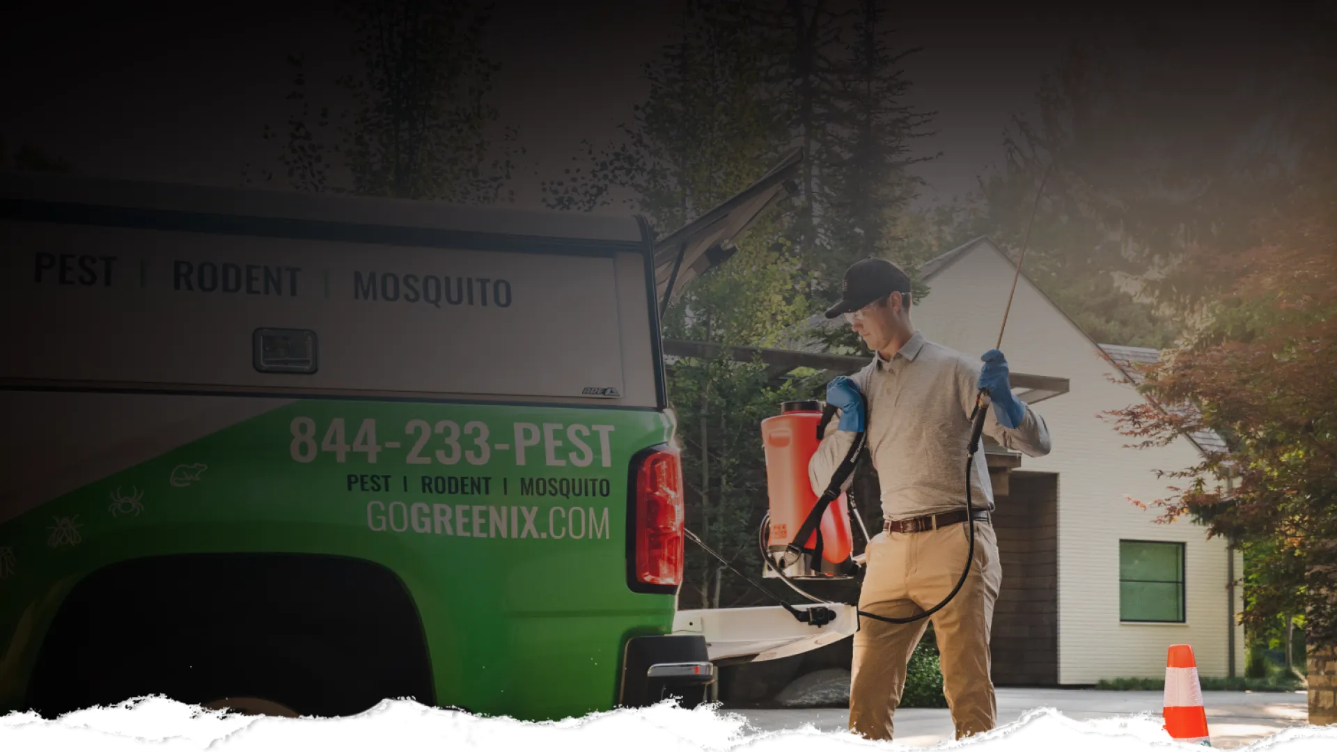 Pest control technician with spray equipment preparing for service next to green and white company truck by house.