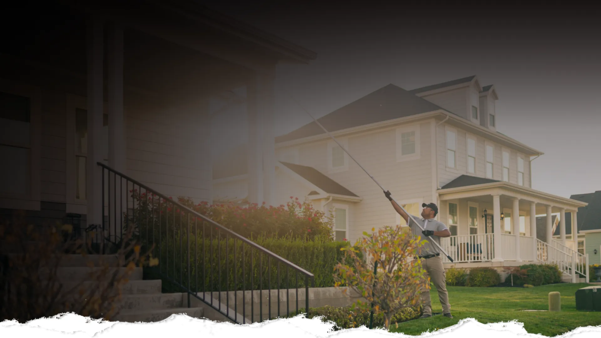 Man spraying pesticide on plants in front of a suburban house during daytime.