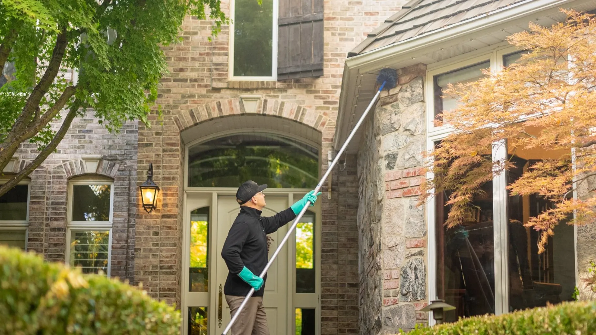 a pest tech eave sweeping the front of a house