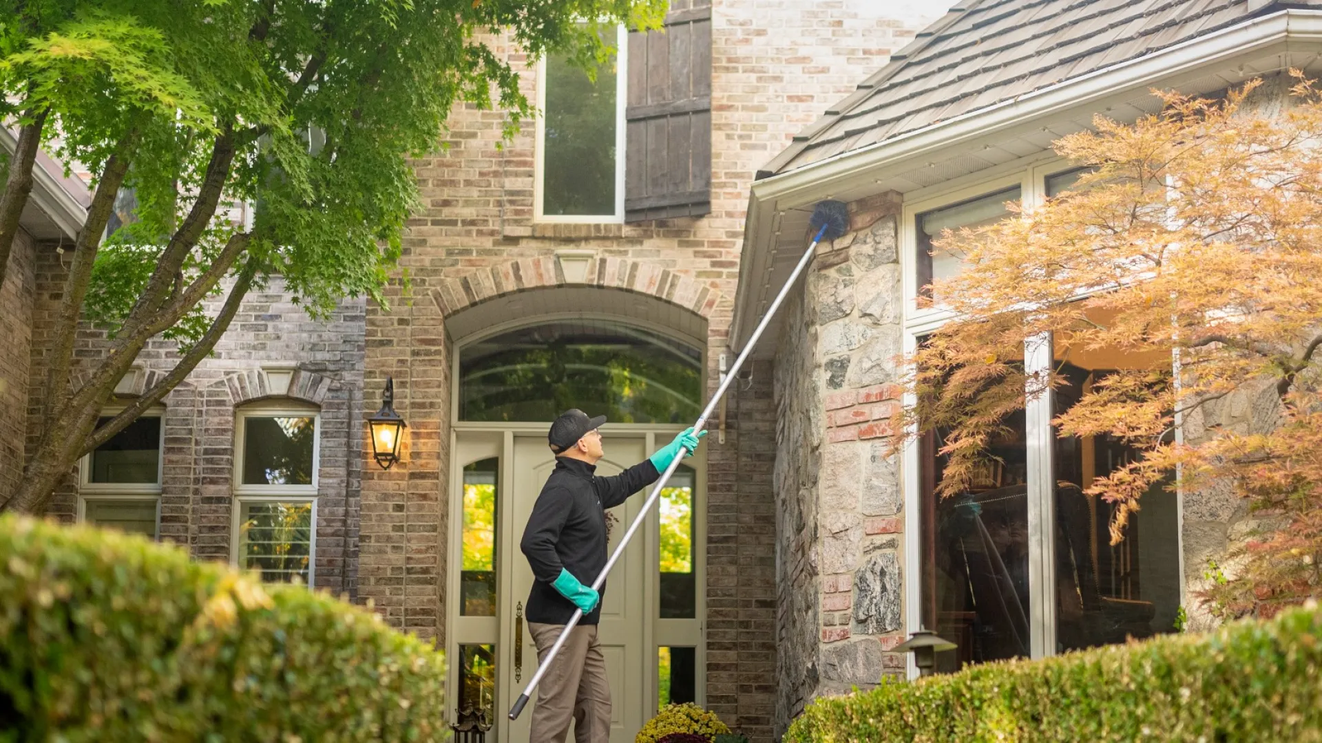 a pest tech eave sweeping the front of a house