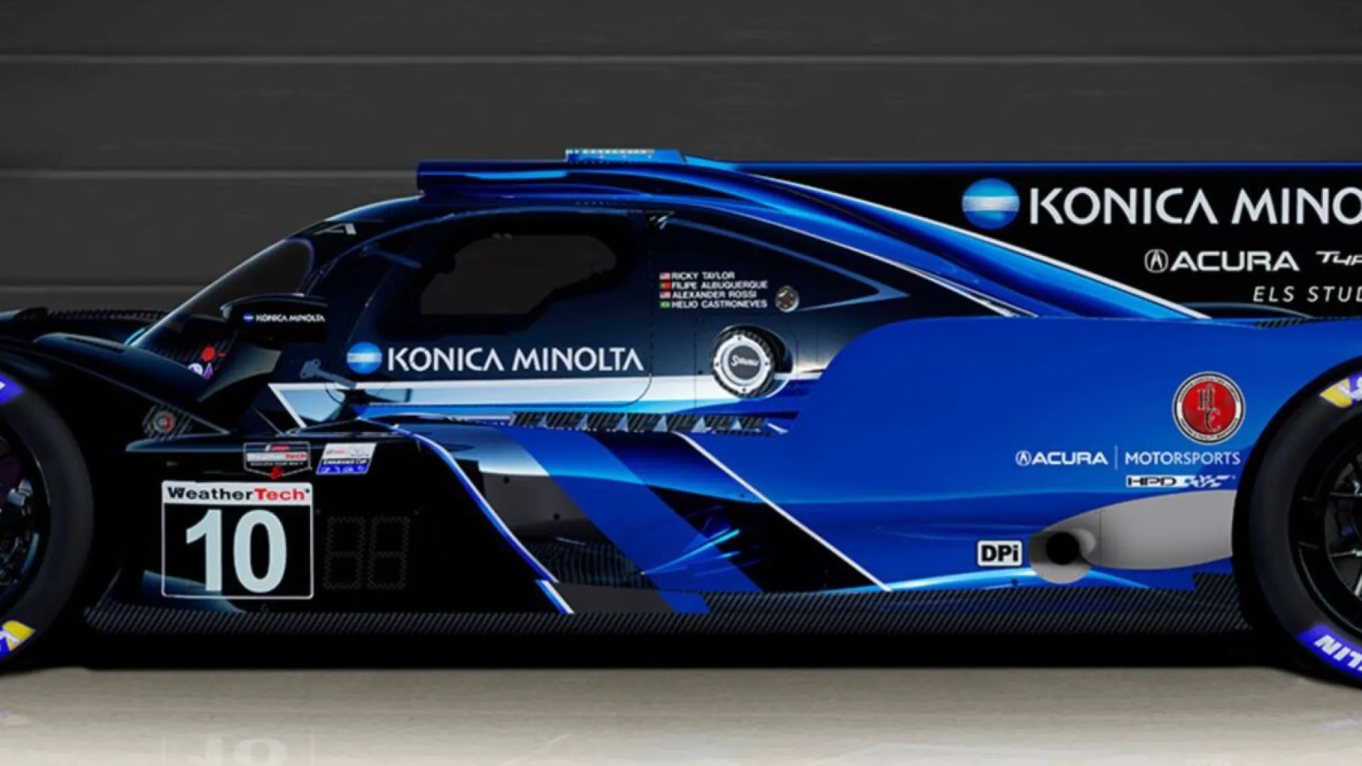 Blue and black Acura Konica Minolta racing car with aerodynamic design and Michelin tires on a gray surface.
