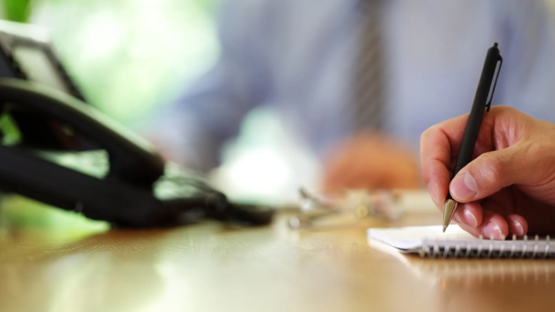 a person sitting at a table with a pen