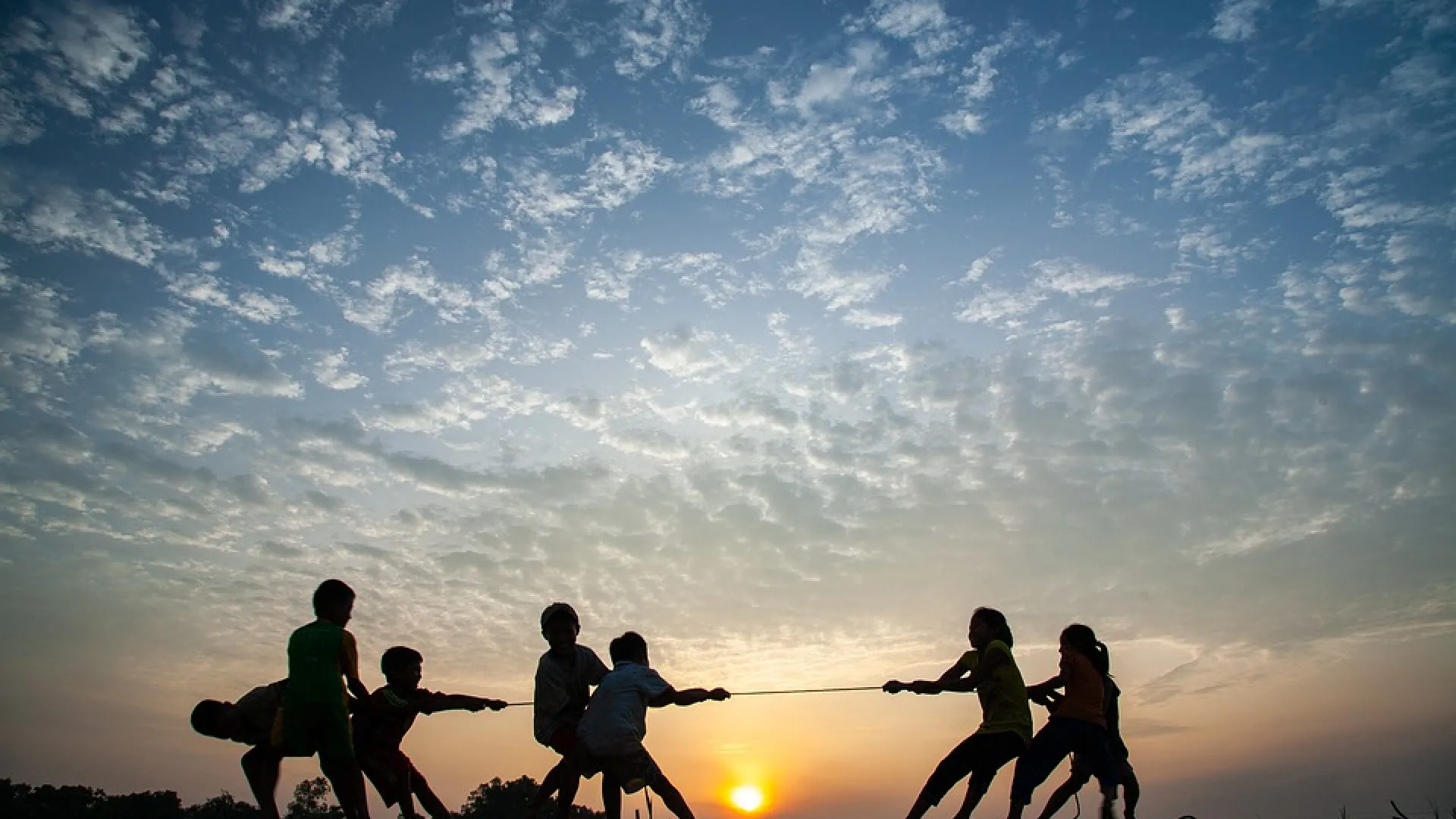 children play tug of war with rope