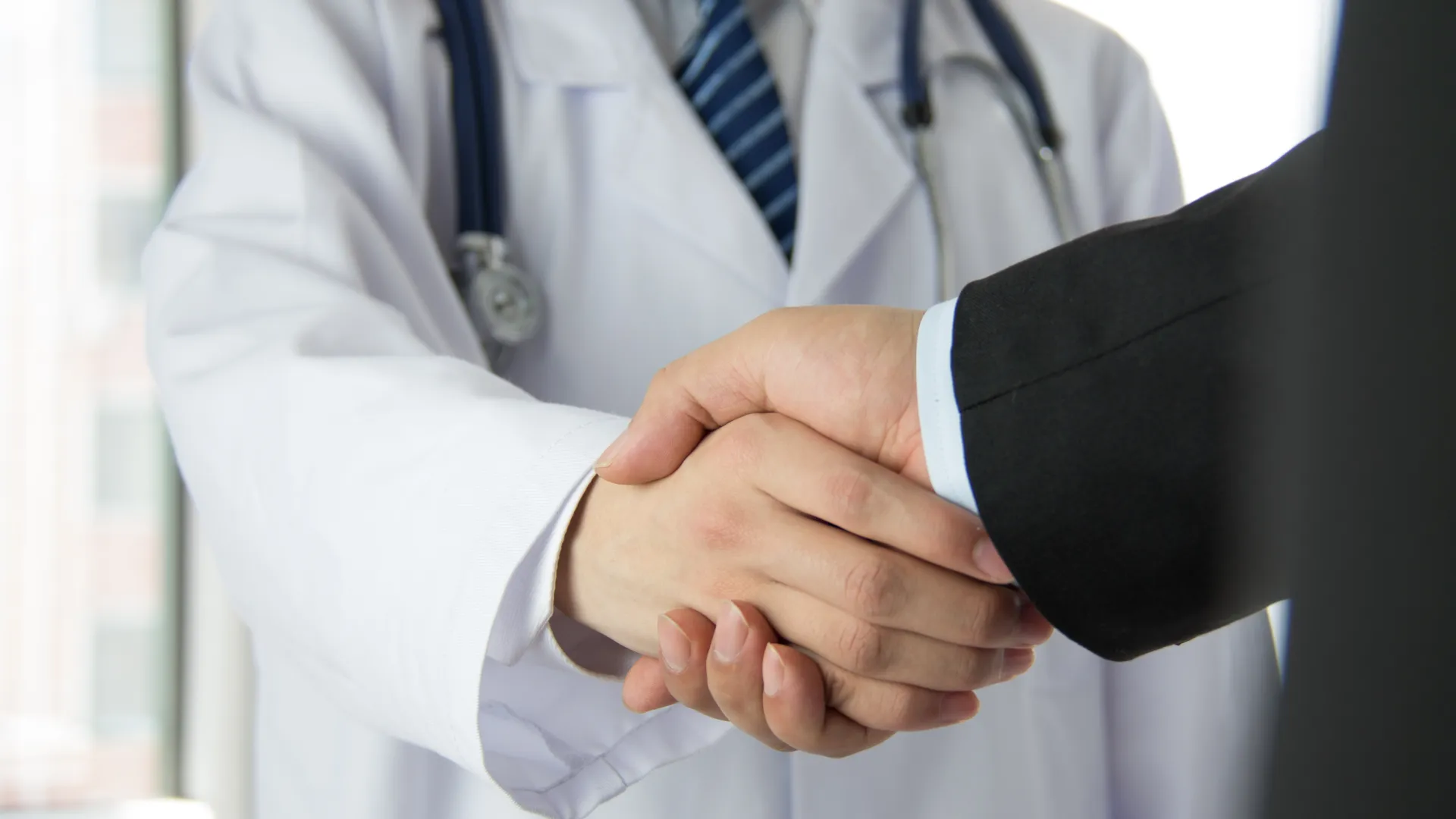 Doctor shaking the hand of a man in a suit