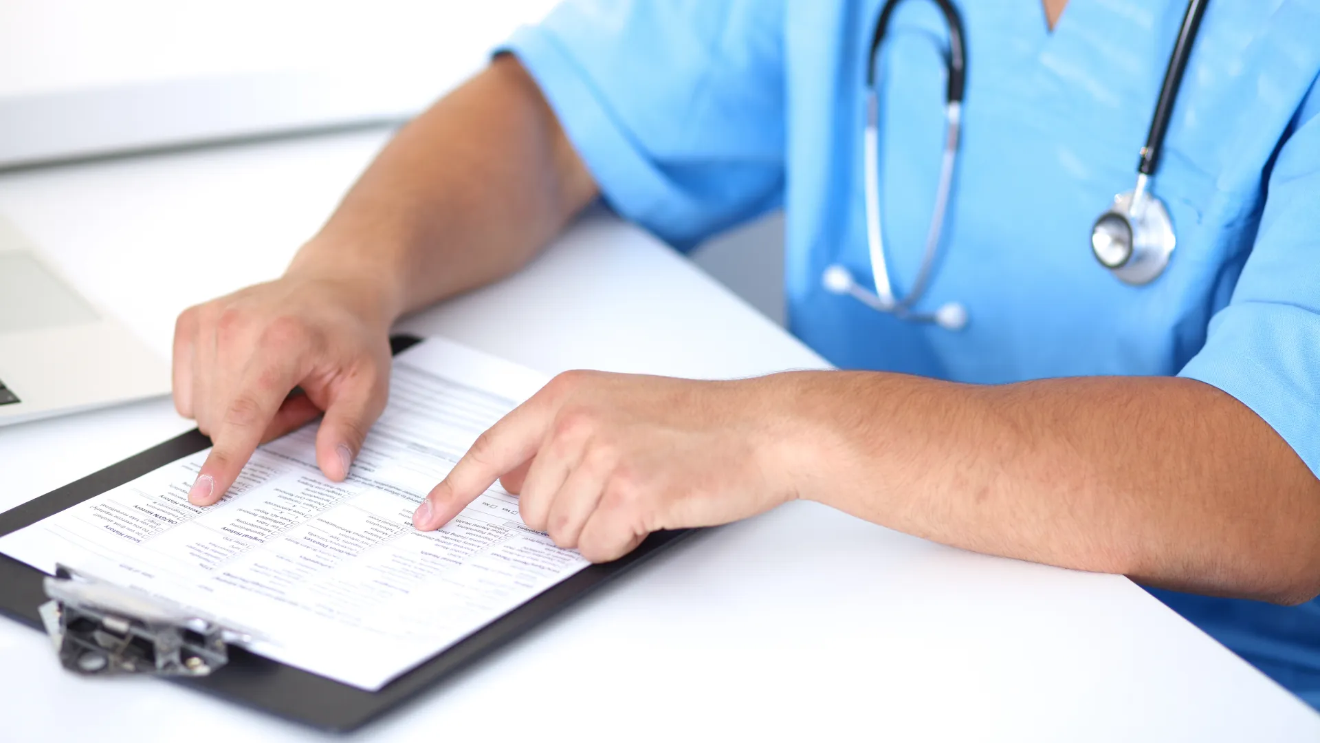 a medical professional reads a document handout on a clipboard