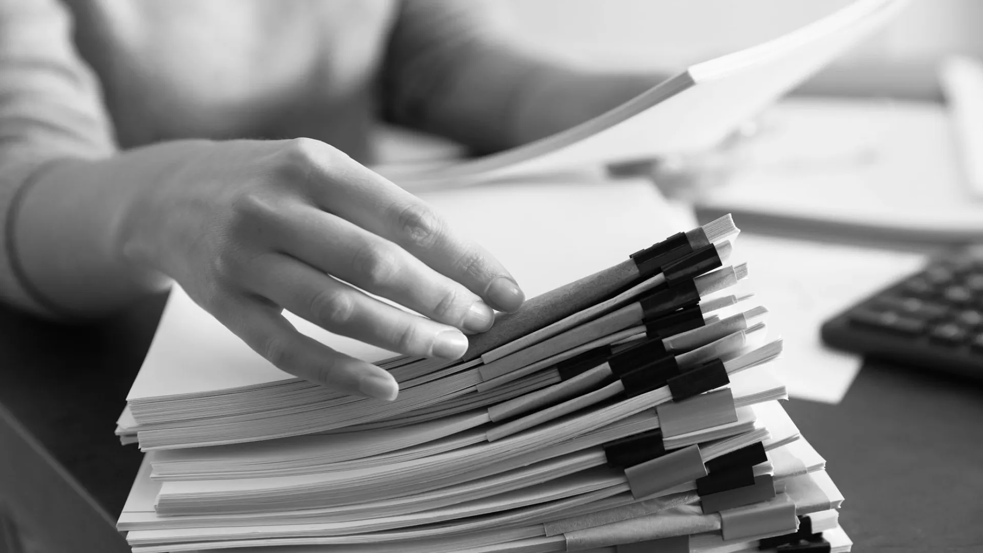 a close-up of hands on a pile of books