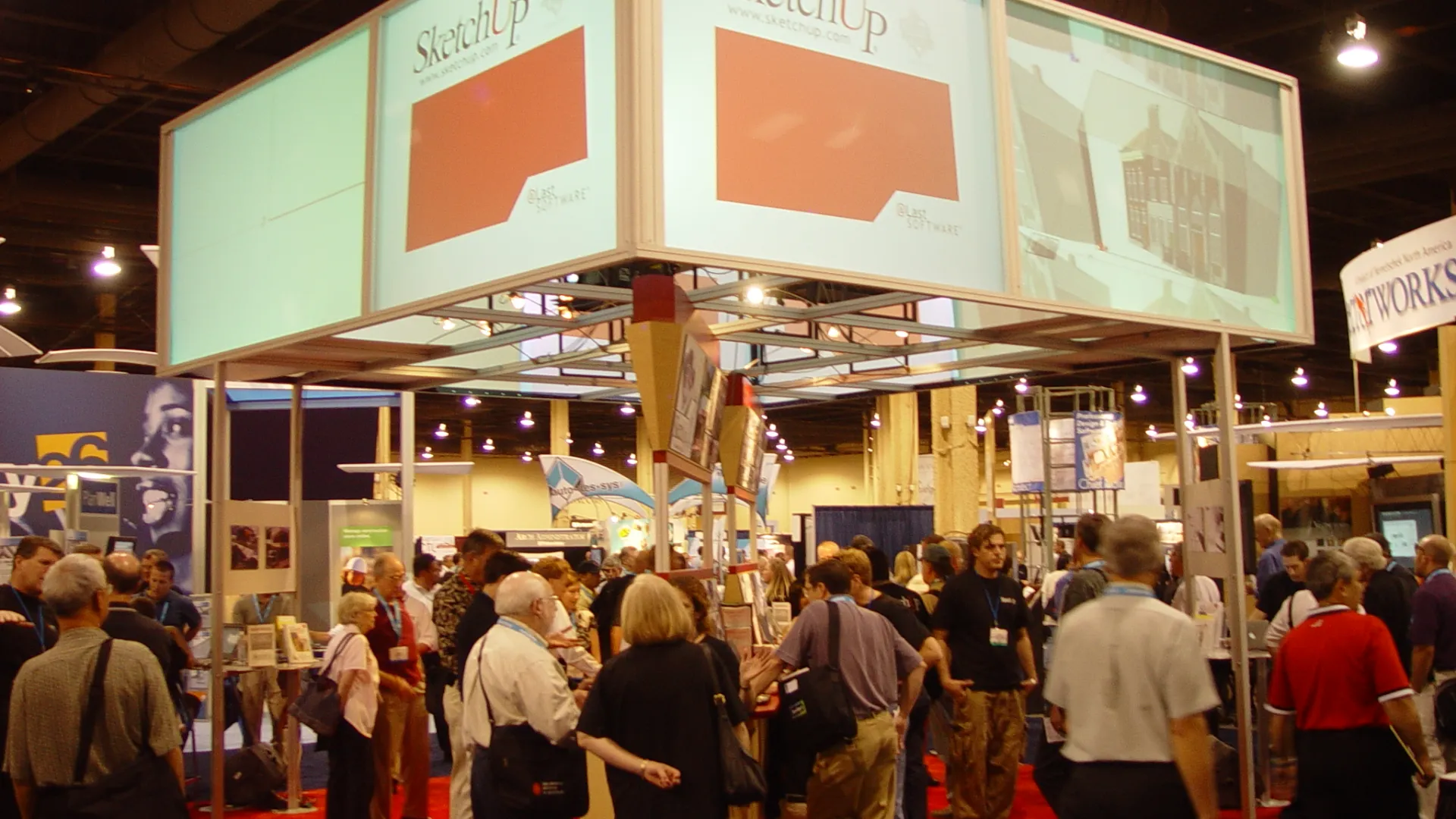 Busy SketchUp booth at a trade show with crowds exploring displays under overhead signage.